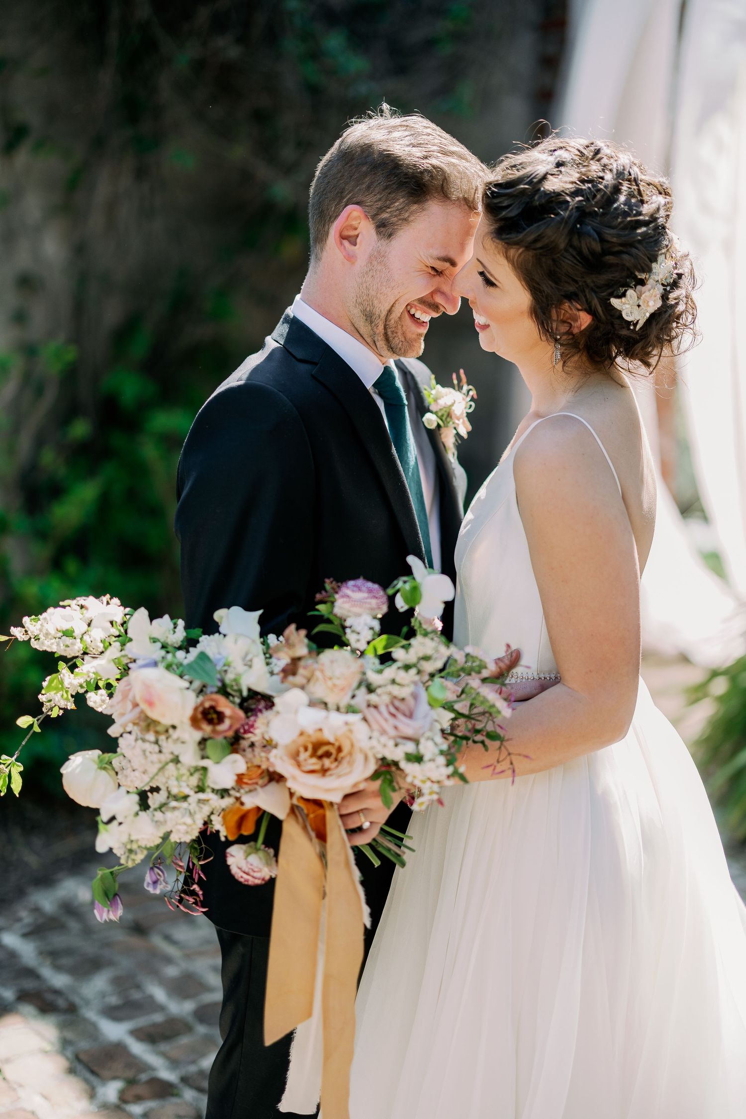 Close up of bride with lush floral bouquet and her groom at Summerour Studio wedding in Atlanta