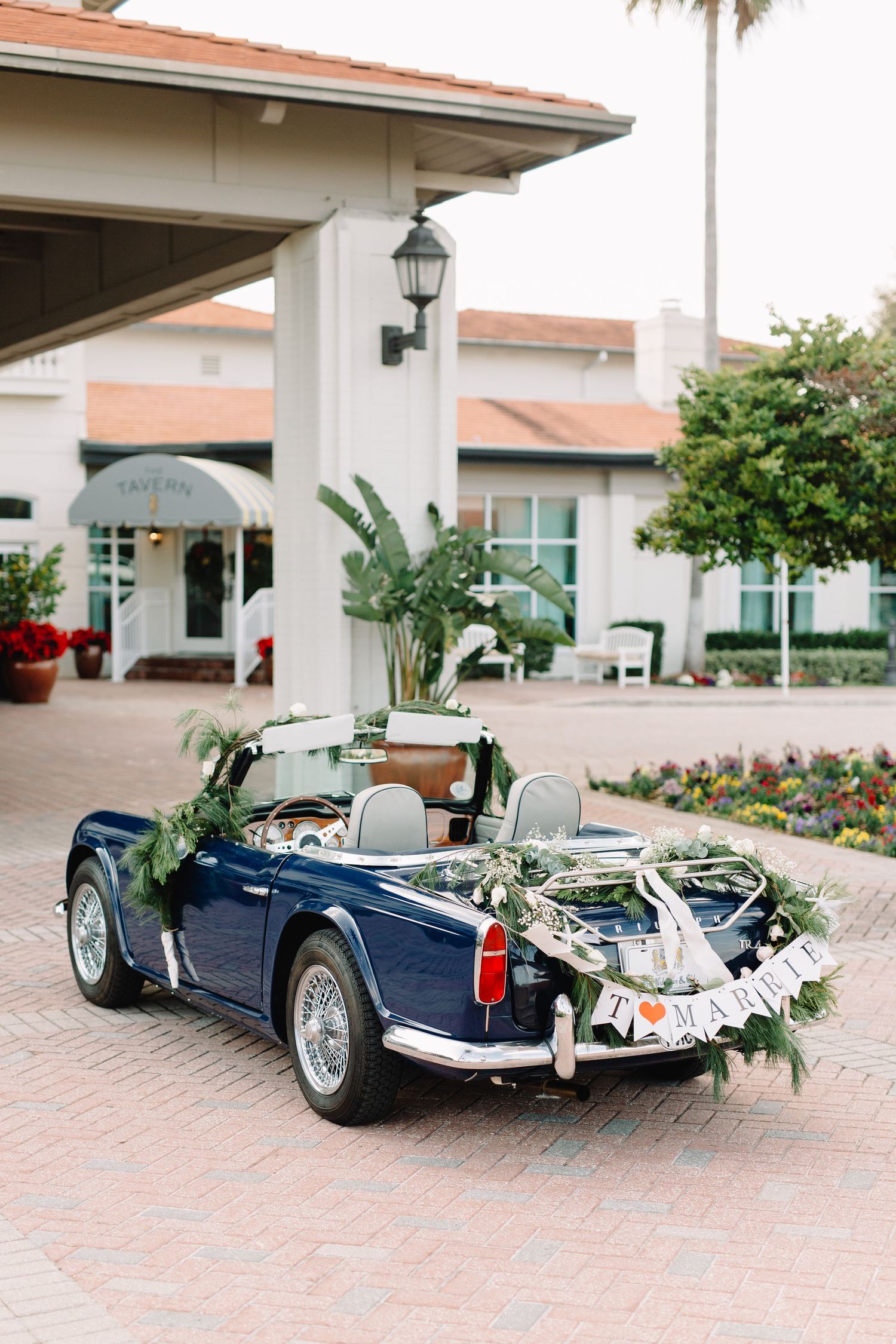 Vintage navy blue convertible with floral garland and just married sign