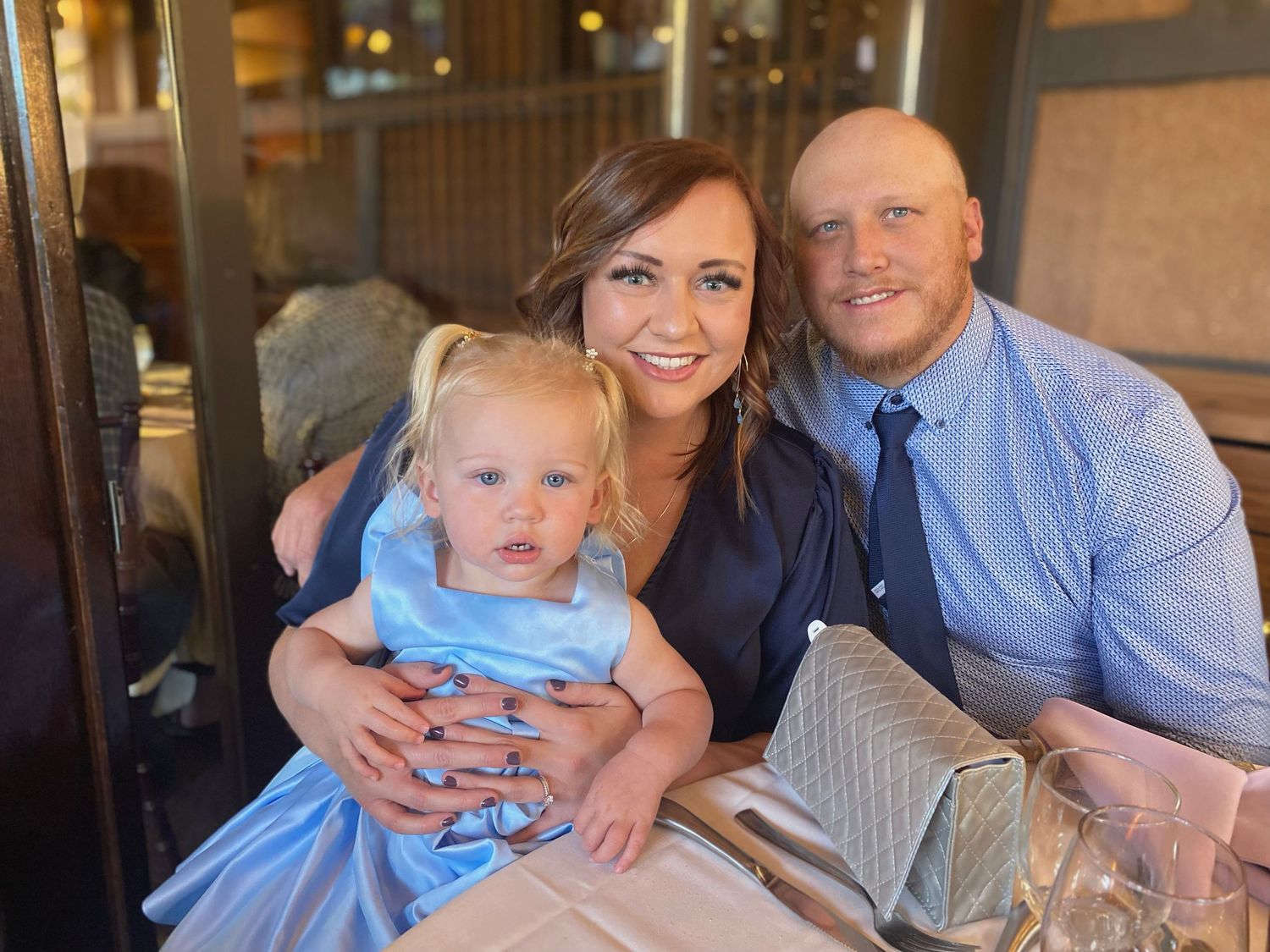 A mother and father holding their child at a wedding  for the website WhiteFlamingoPhotos.com