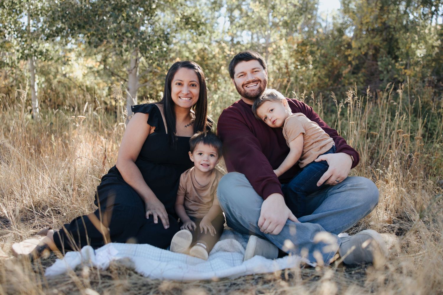 Family portrait session in rustic outdoor setting with natural fall colors.