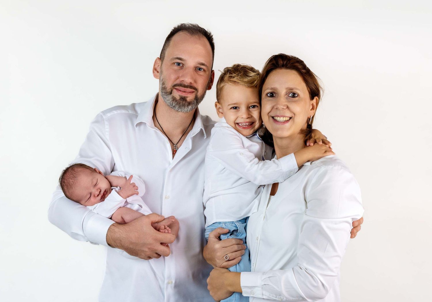 Happy family portrait against white background showing tender moments together.