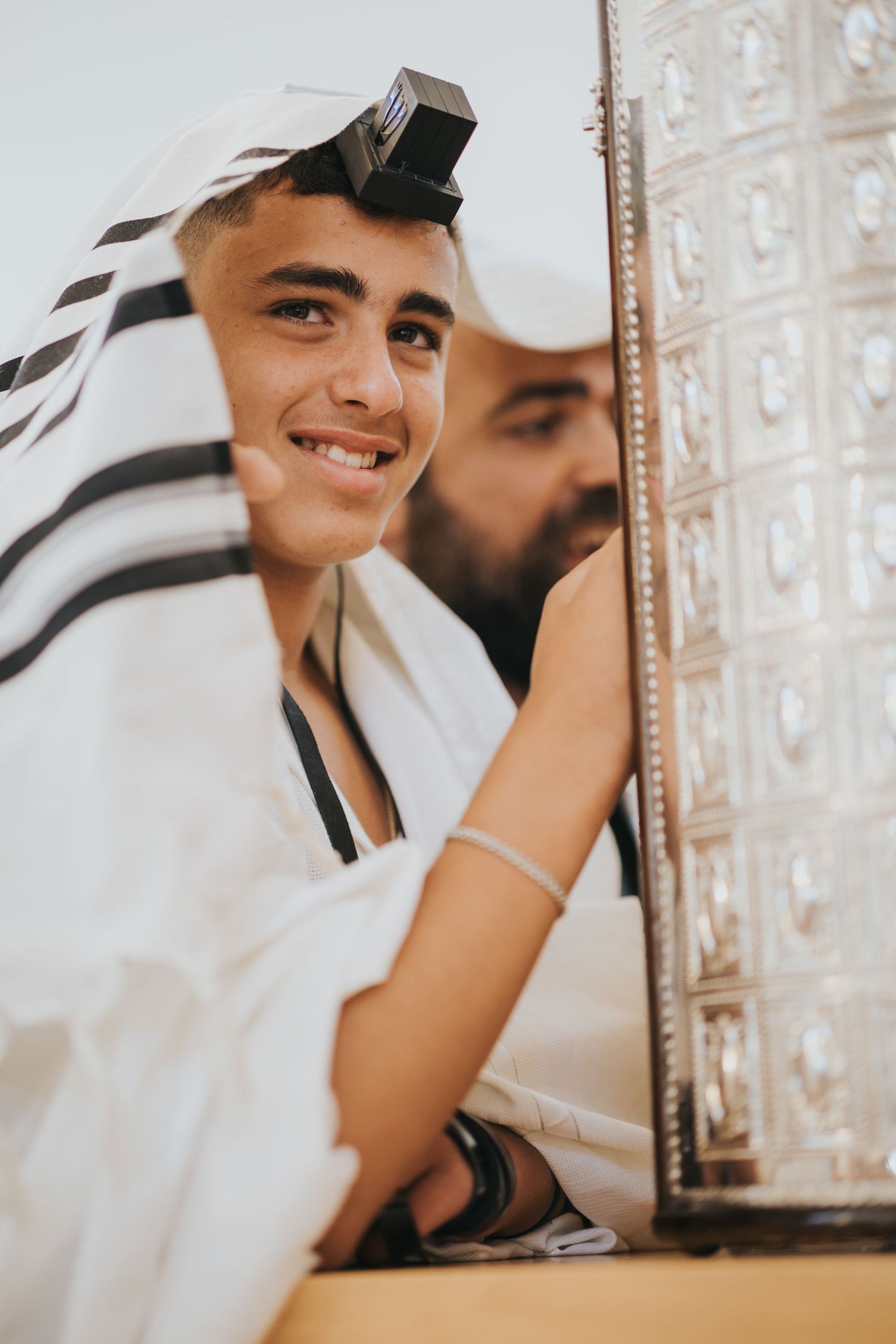 Person in traditional prayer attire participating in a religious ceremony.