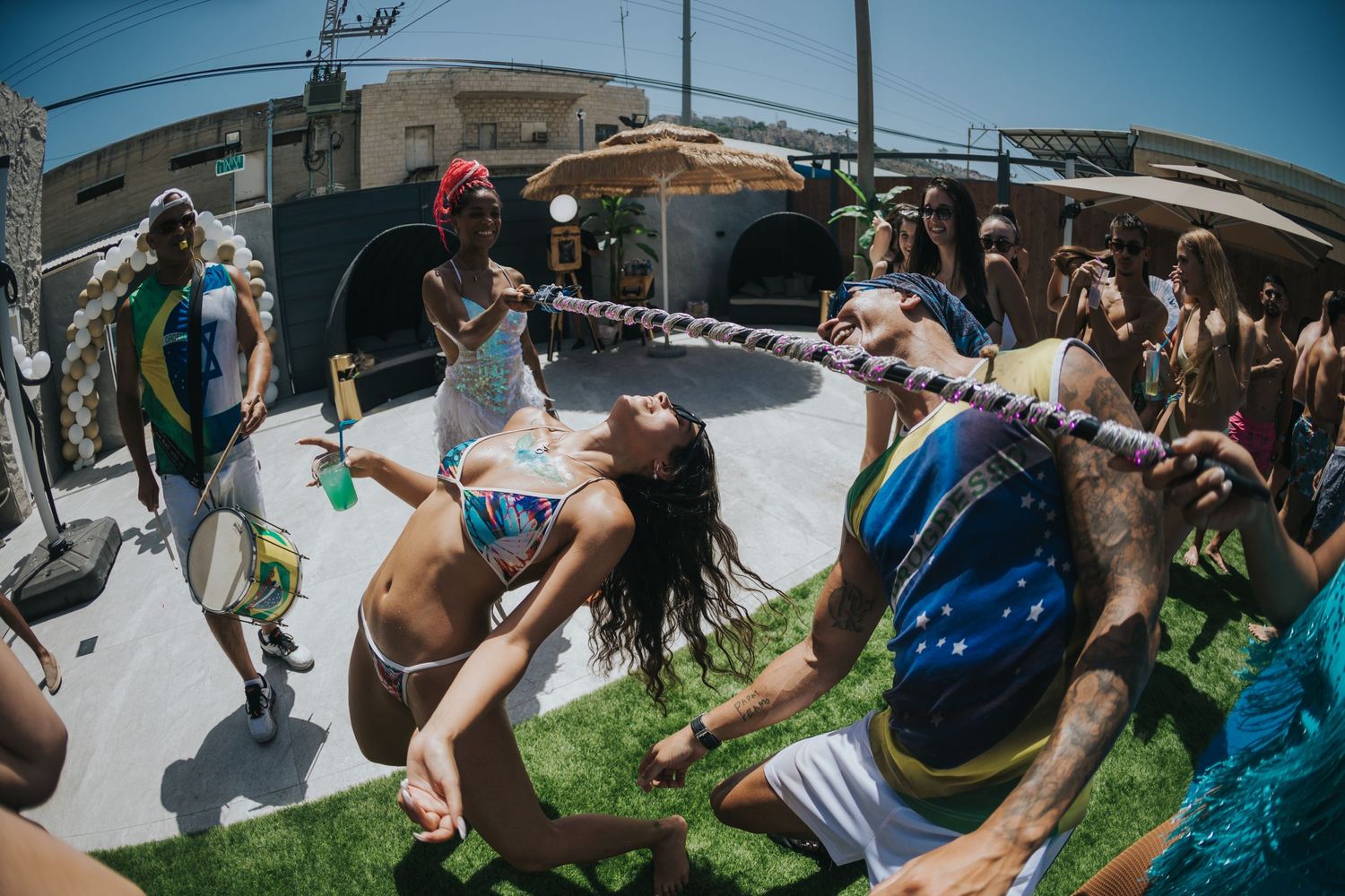 Energetic crowd jumps and dances at an outdoor event in the summer heat.