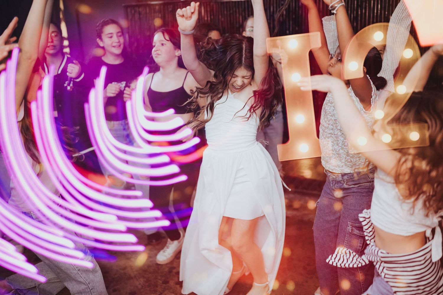 Party scene with dancing silhouettes and purple light trails creating a dynamic nightclub atmosphere.
