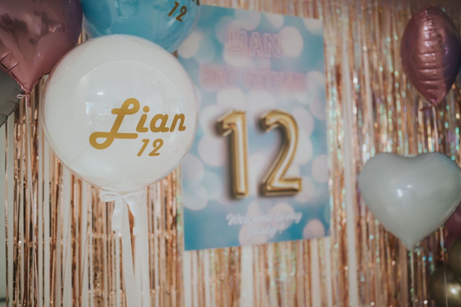Close-up of party decorations showing gold number 12 and celebratory balloons.