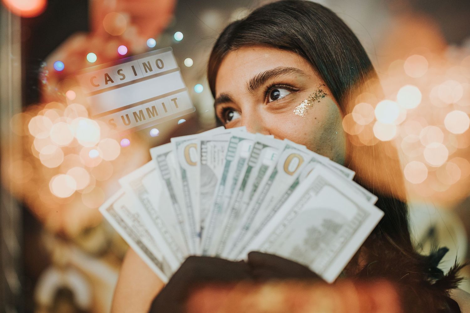 Close-up shot of cash being held up against a blurred casino backdrop with bokeh lights.