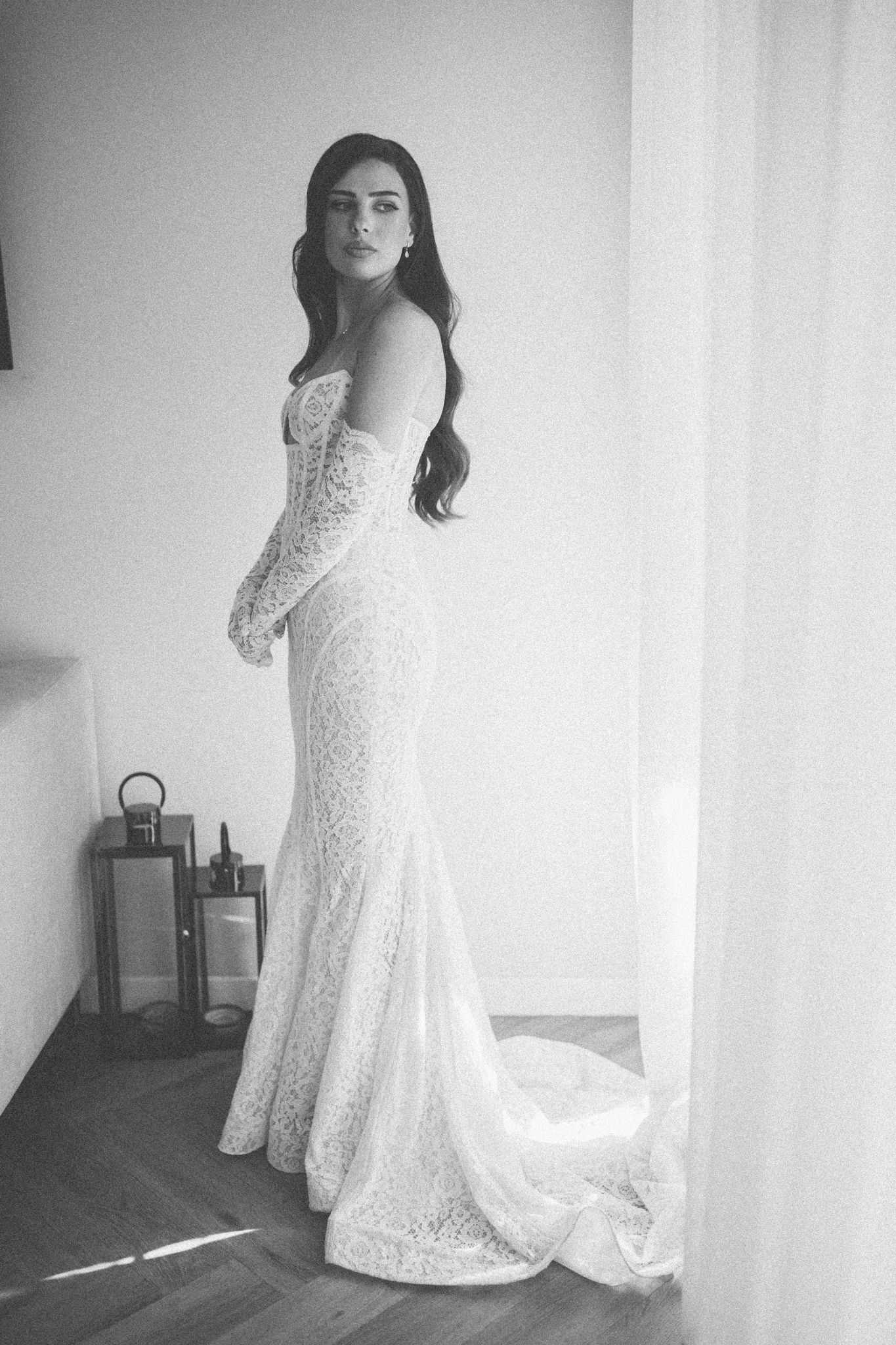 Elegant bridal portrait featuring lace fitted wedding gown in black and white.