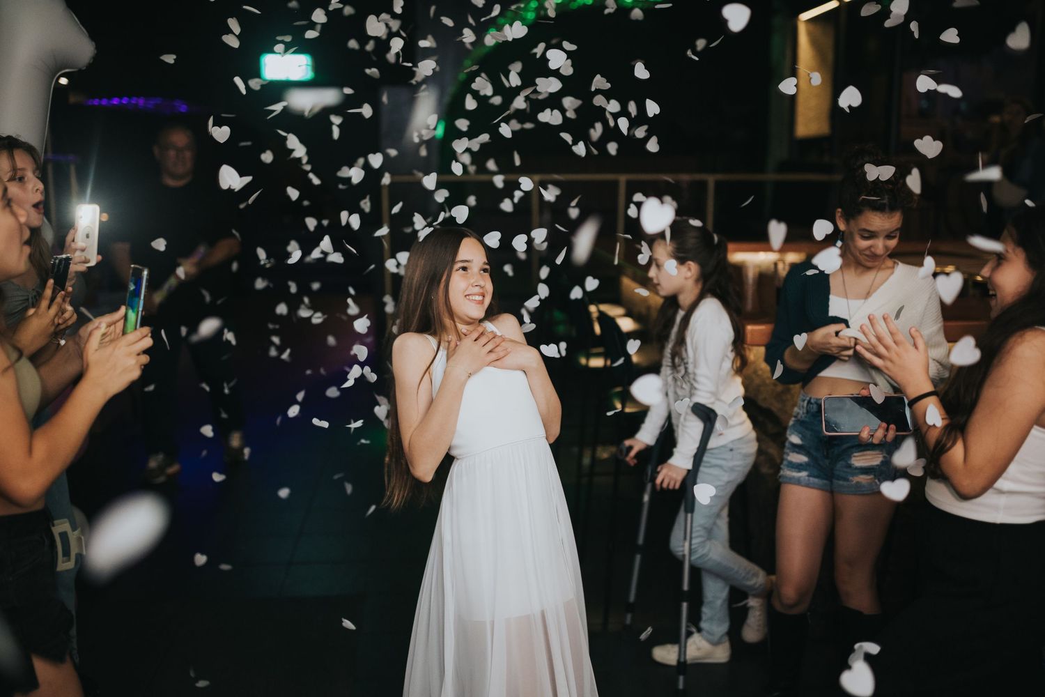 Party scene with confetti falling and people dancing in a nightclub setting.