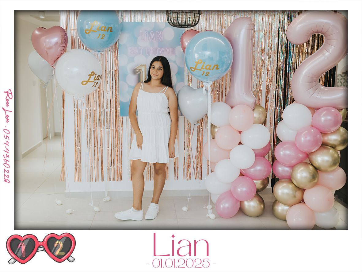 A celebration setup with pink and gold balloons against a sparkly backdrop.