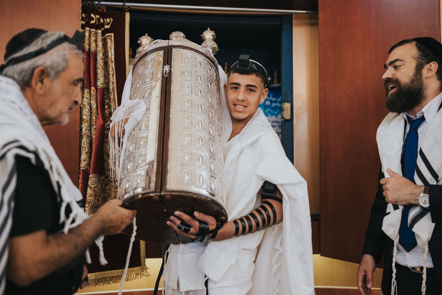 People participating in a traditional Torah reading ceremony with ritual garments.