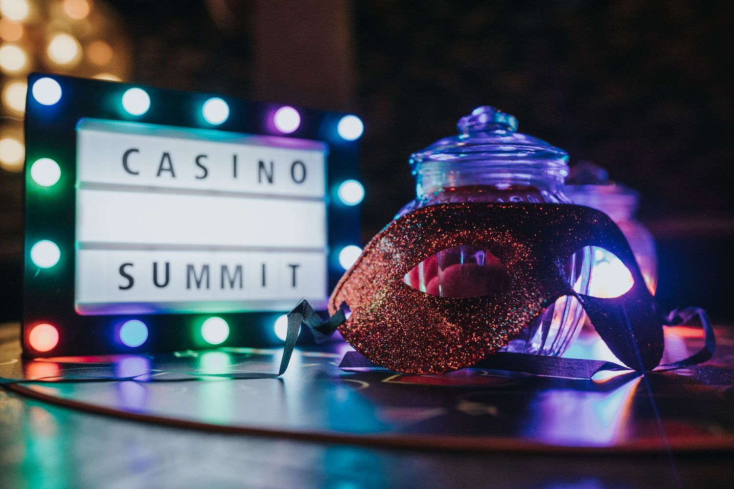 Illuminated casino sign and decorative mask with purple lighting create a moody nighttime atmosphere.