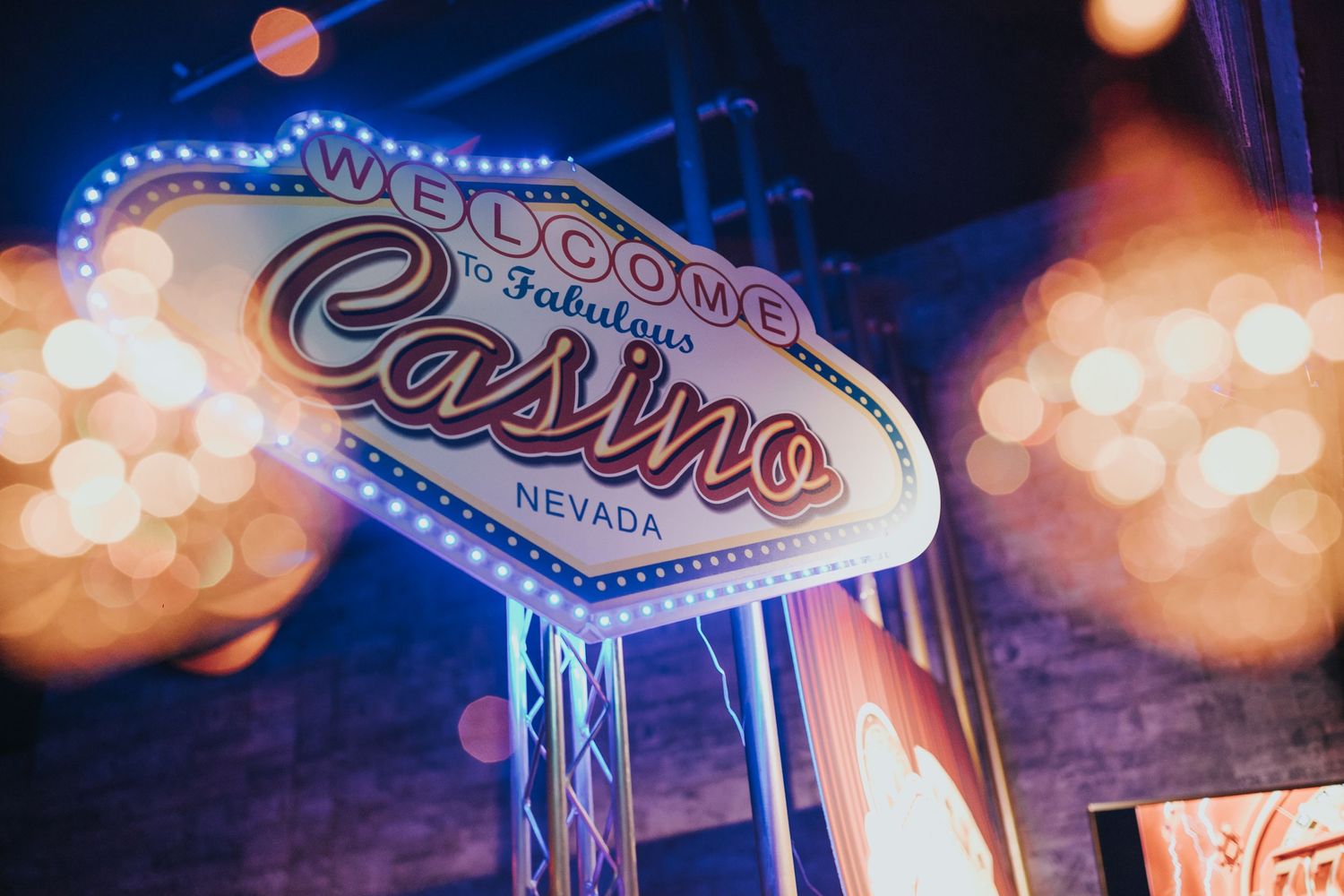 Illuminated vintage casino sign in Nevada glowing against a bokeh background at night.
