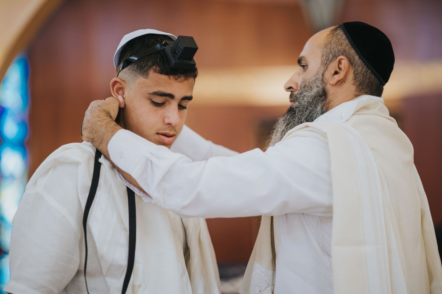 A religious ceremony showing the wrapping of tefillin in a synagogue setting.