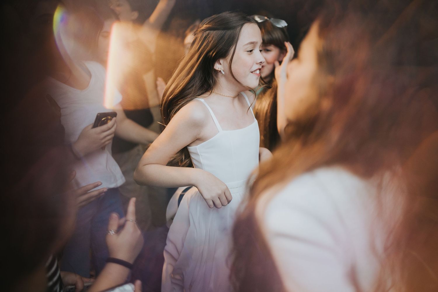 Dancing in white dress captured with atmospheric party lighting.