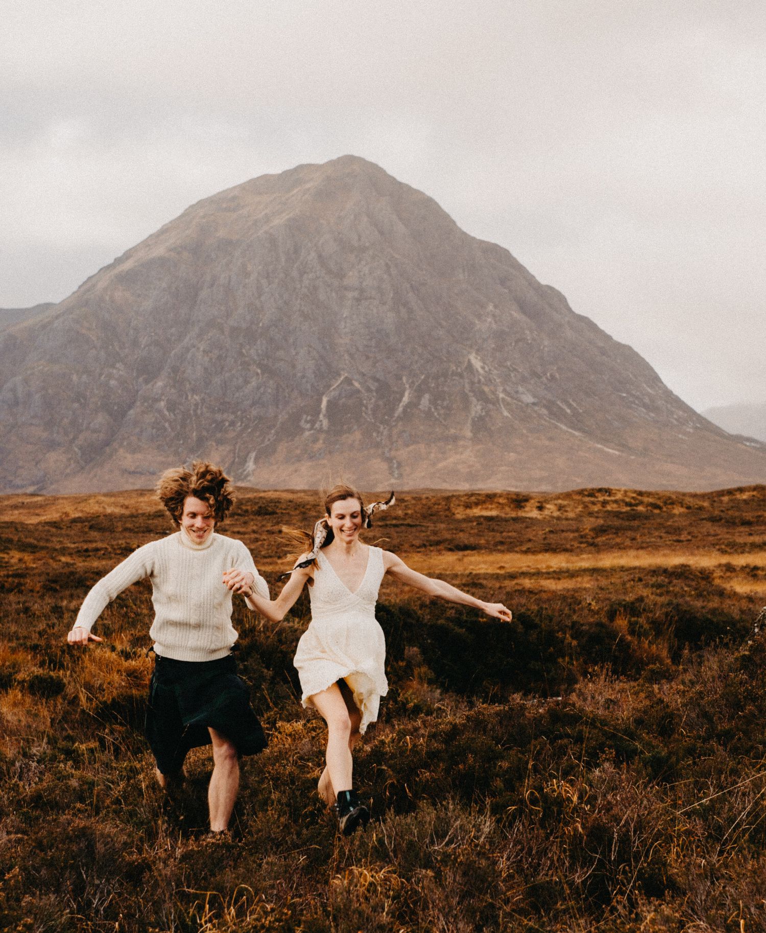 Self portrait of couple photographers running towards the camera in the Scottish highlands.