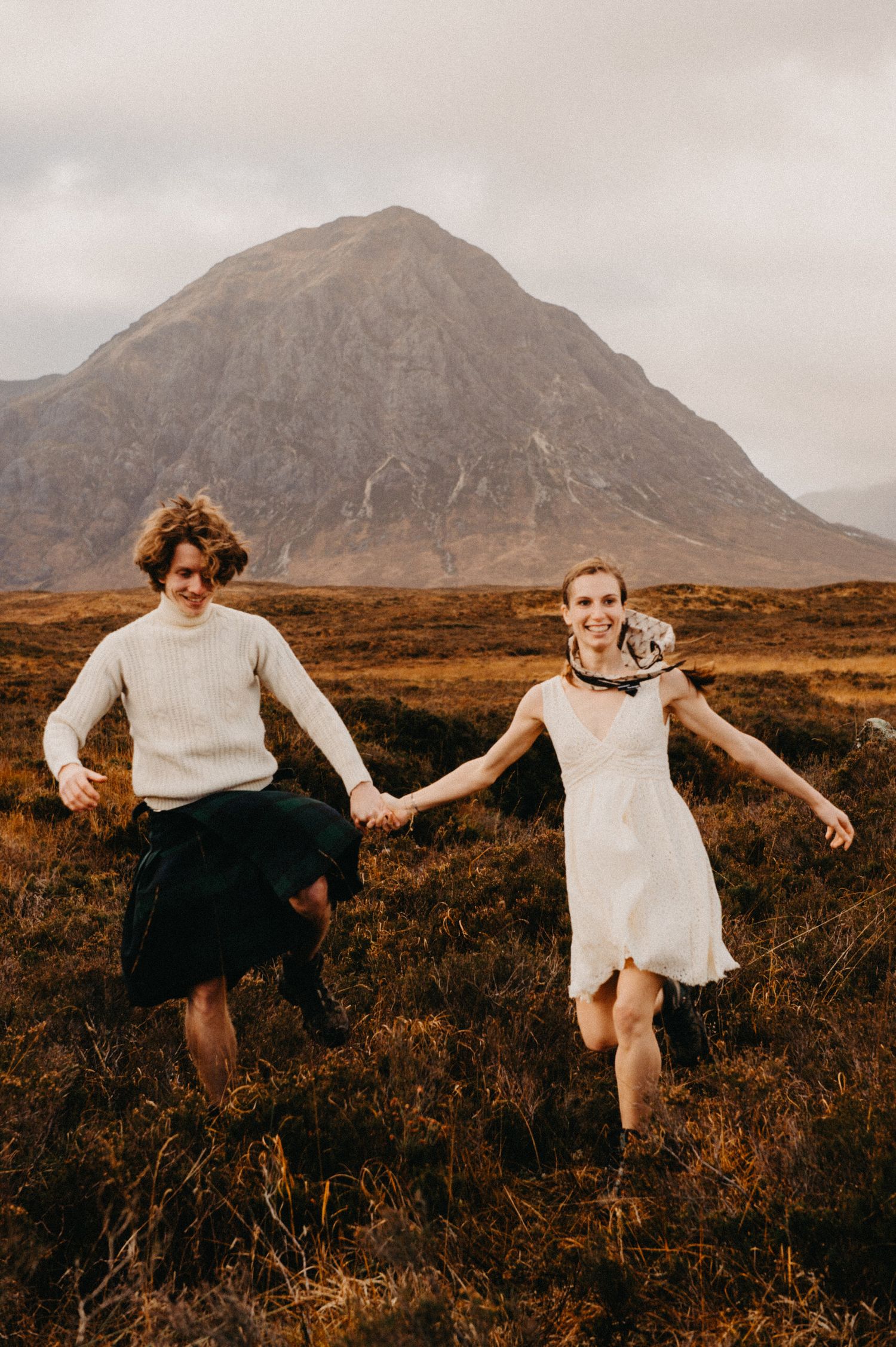 Self portrait of couple photographers running towards the camera in the Scottish highlands.