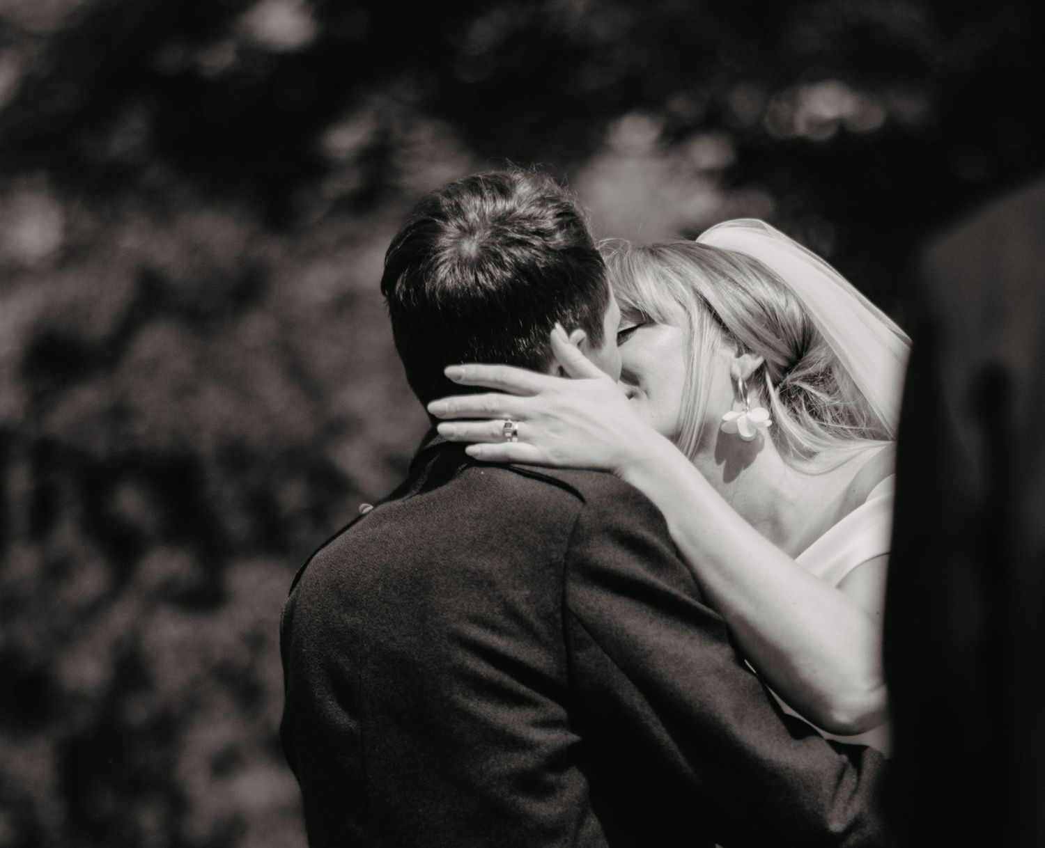 Bride and groom first kiss during countryside wedding in Scotland.
