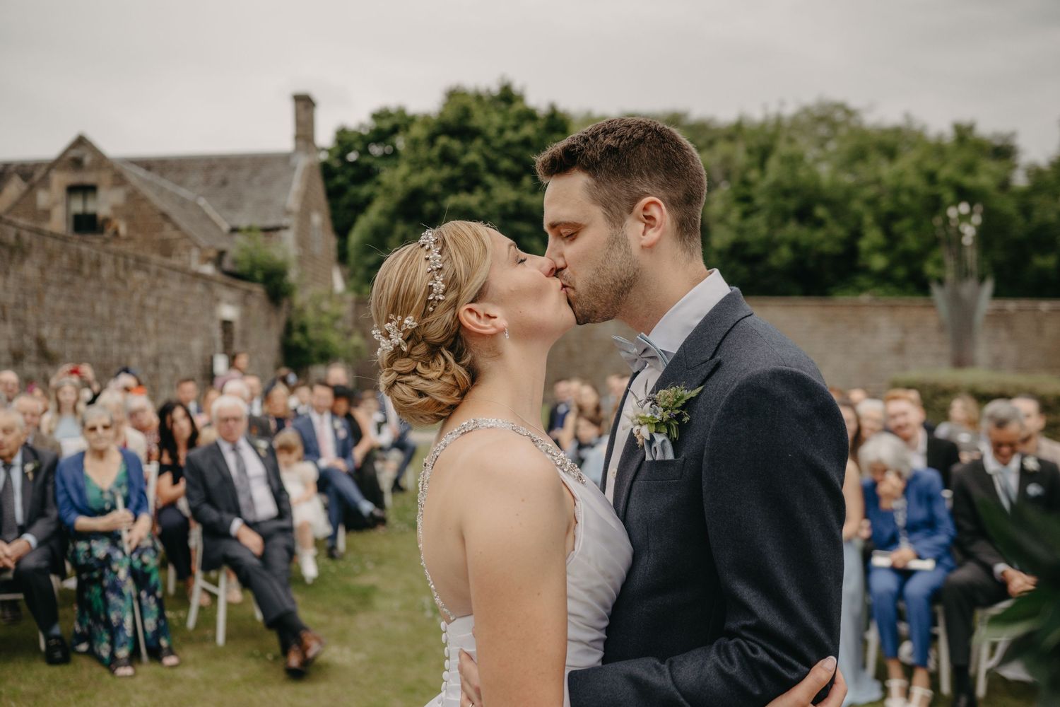 Bride and groom first kiss during Scottish castle wedding.