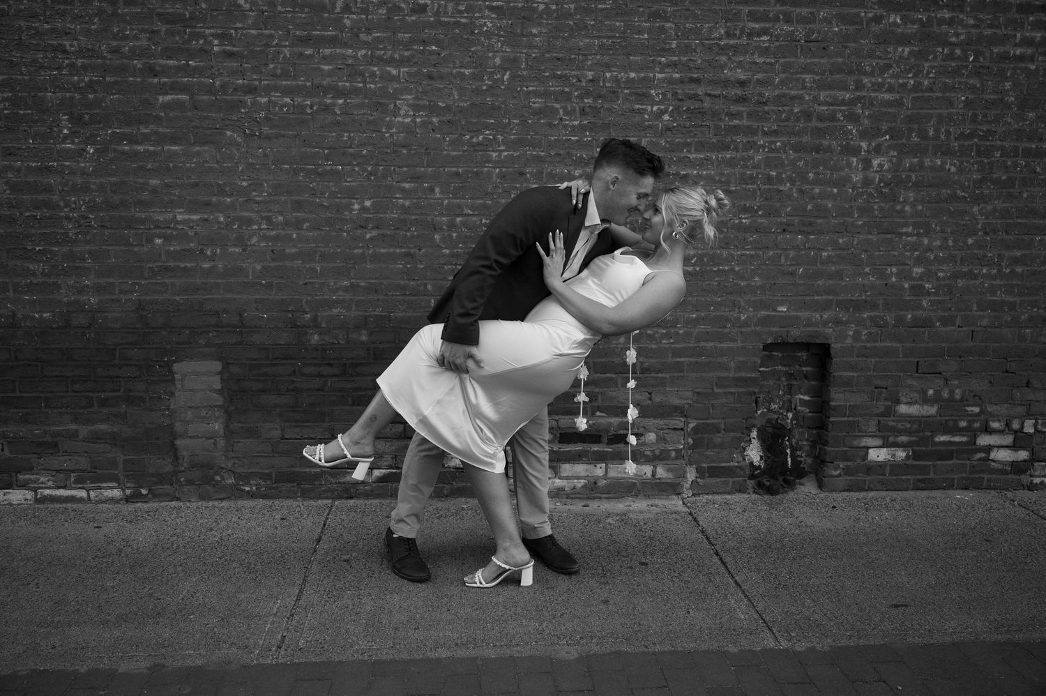 Black and white photo sequence showing playful poses against a brick wall.