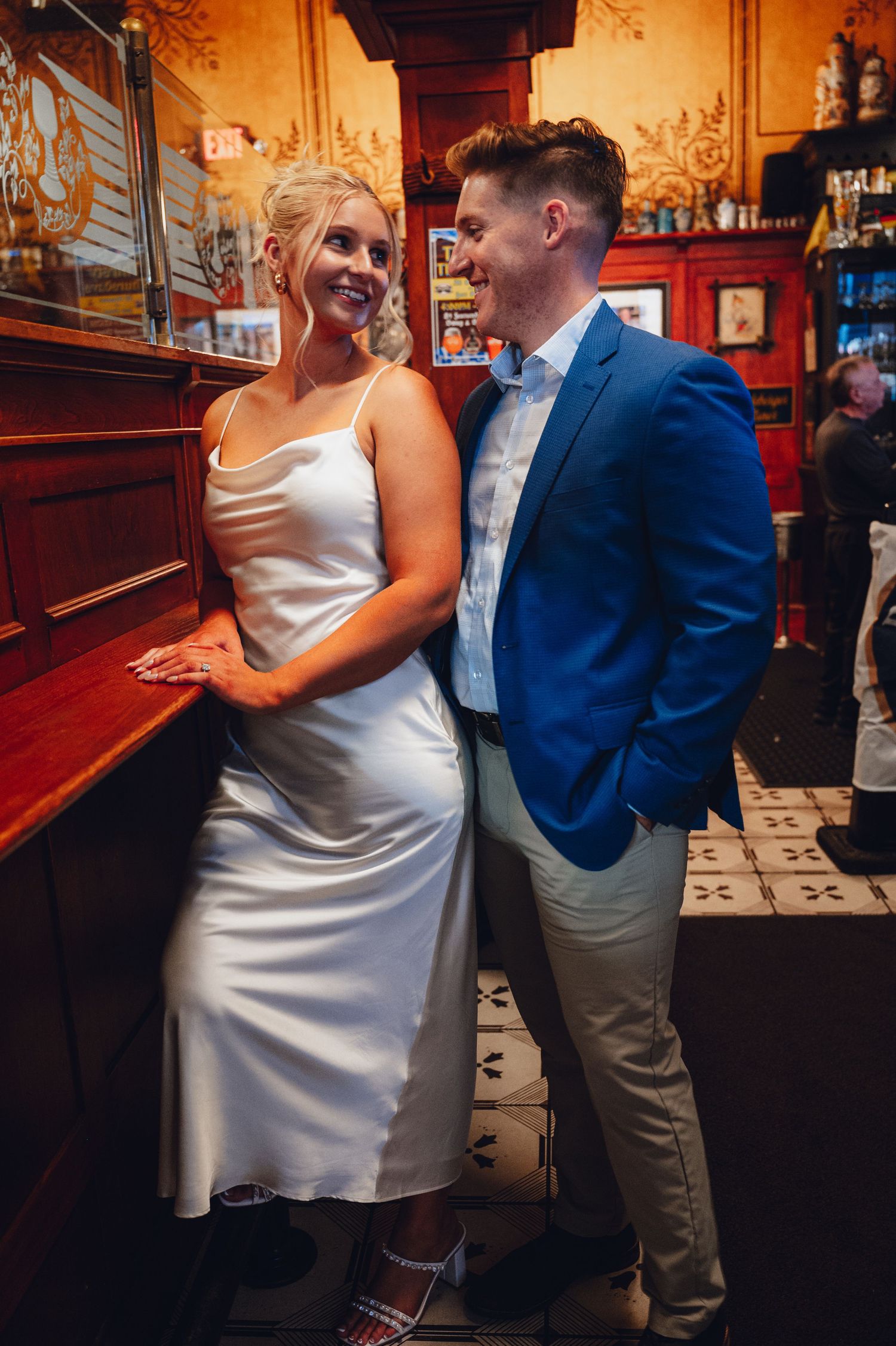 A couple dancing and laughing together in a warmly lit restaurant setting.