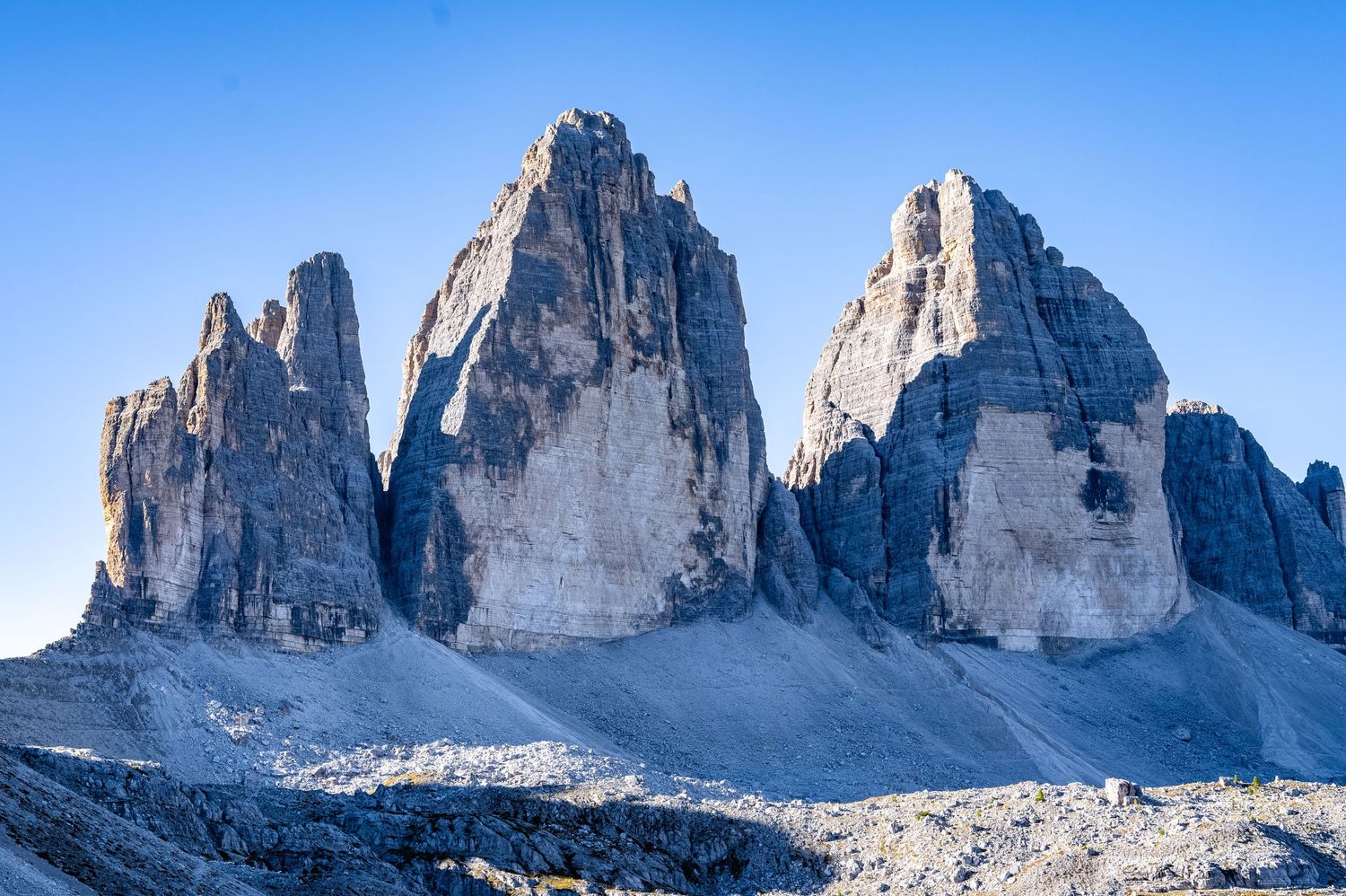 Dramatic mountain peaks of the Dolomites against clear blue sky in Italy.