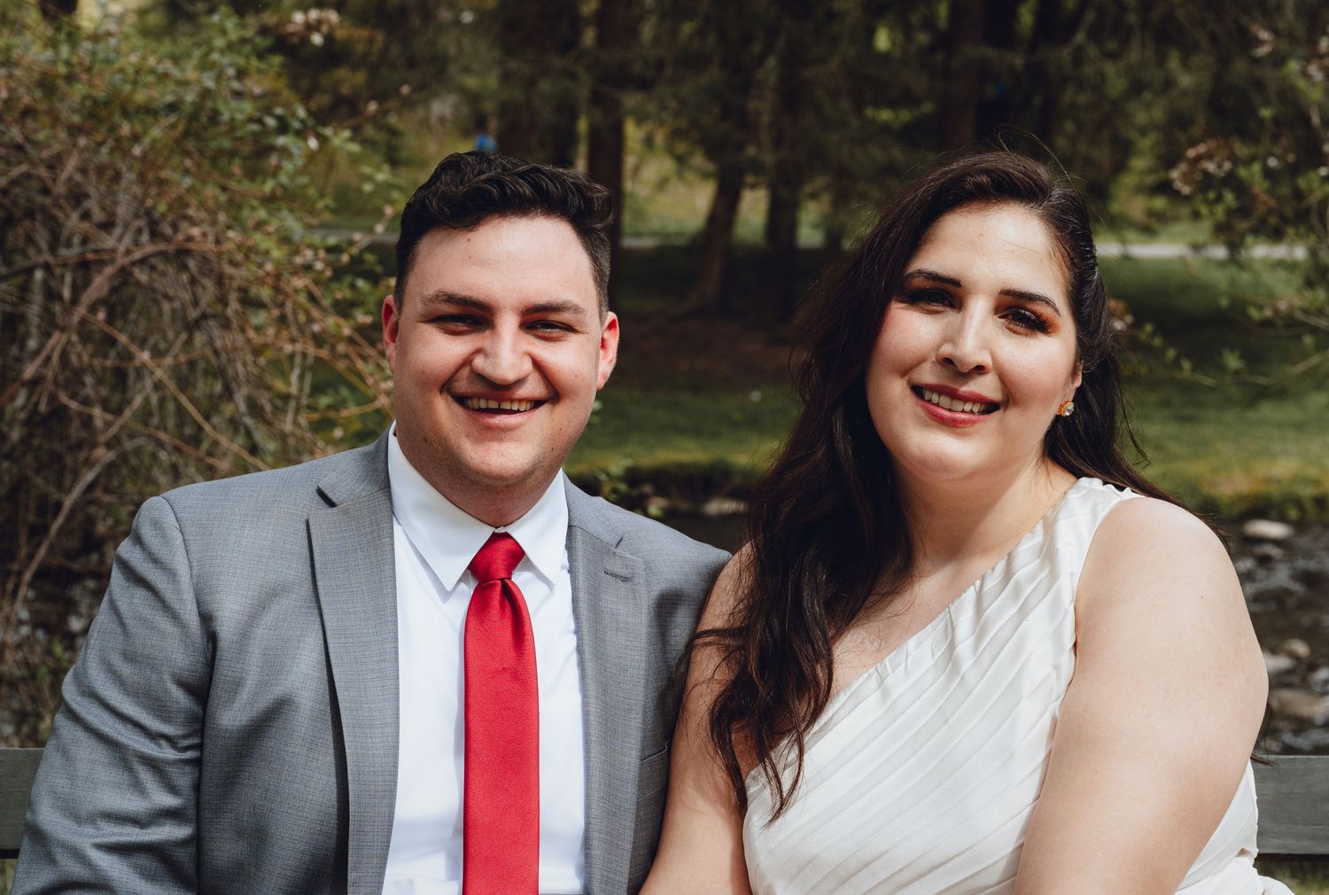 Wedding portraits showing couple in formal attire with red accents against natural outdoor backgrounds.