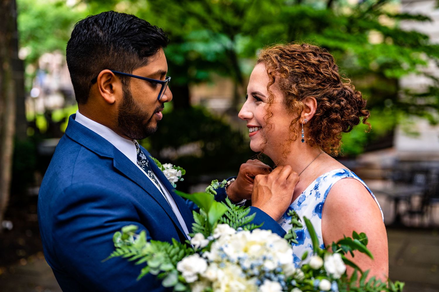 Wedding couple sharing a romantic moment in a garden setting.