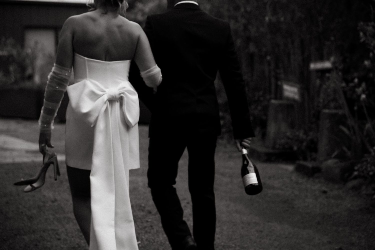 Black and white photo showing the back of a wedding dress with an elegant bow detail.