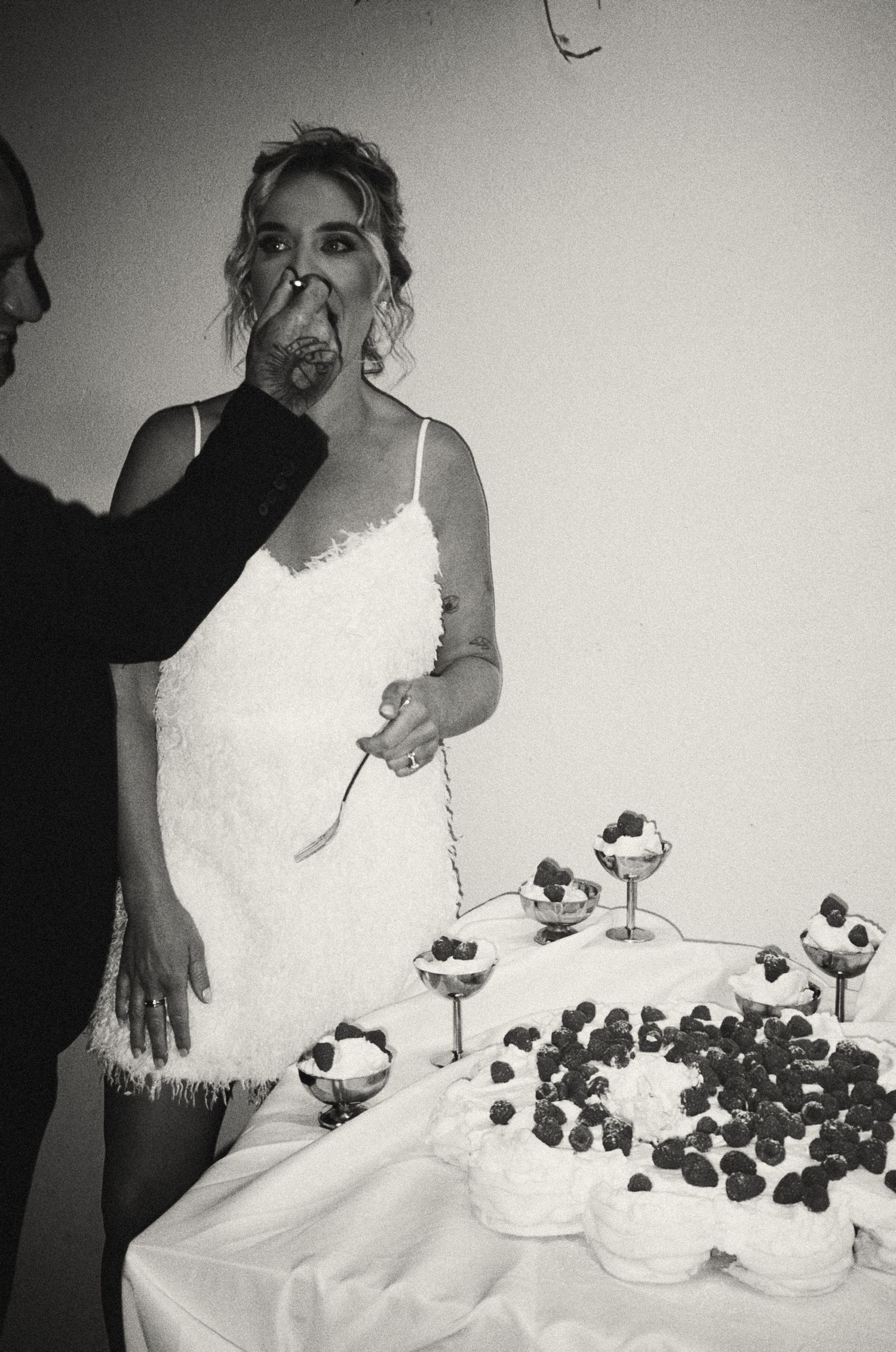 A wedding dessert display featuring multiple tiers of chocolate covered treats on white tablecloths.