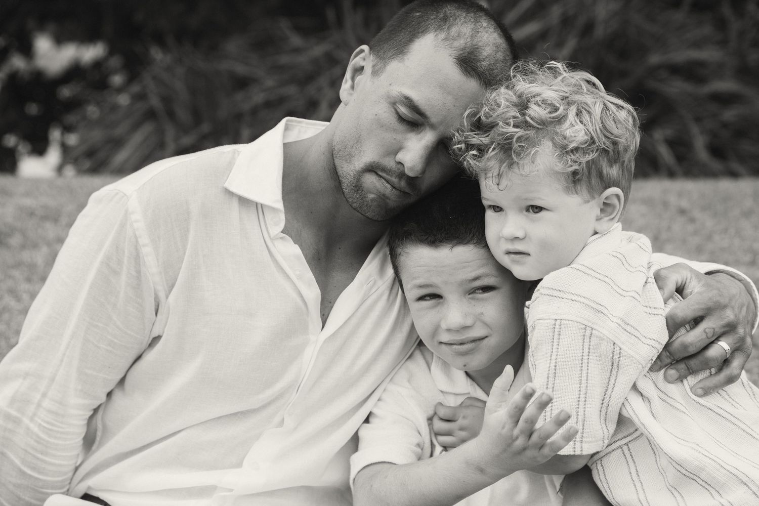 Black and white photo series showing intimate family bonding moments between parent and child in gentle outdoor settings.