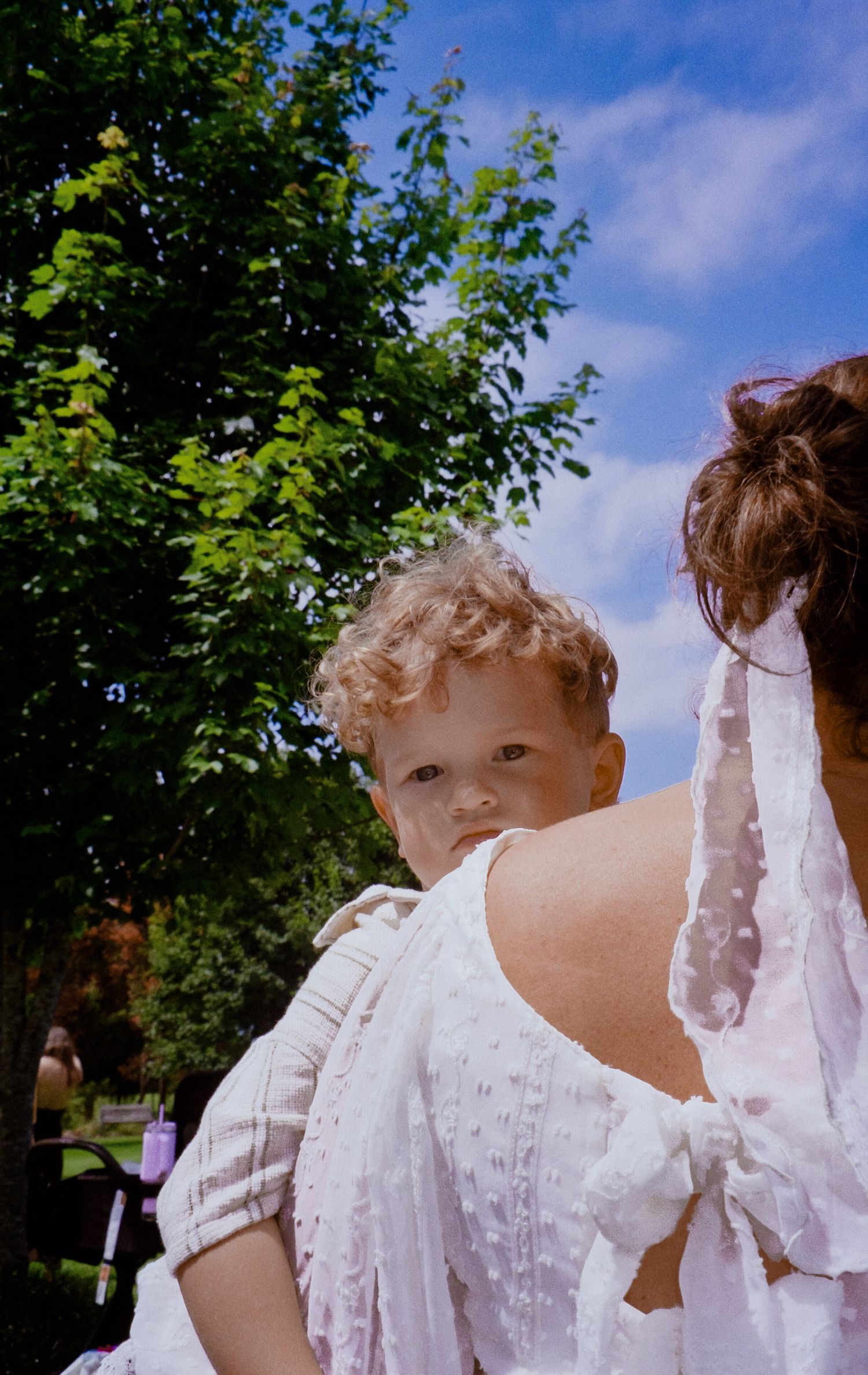 Playful sequence of a child peeking through delicate white lace fabric against a summer garden backdrop.