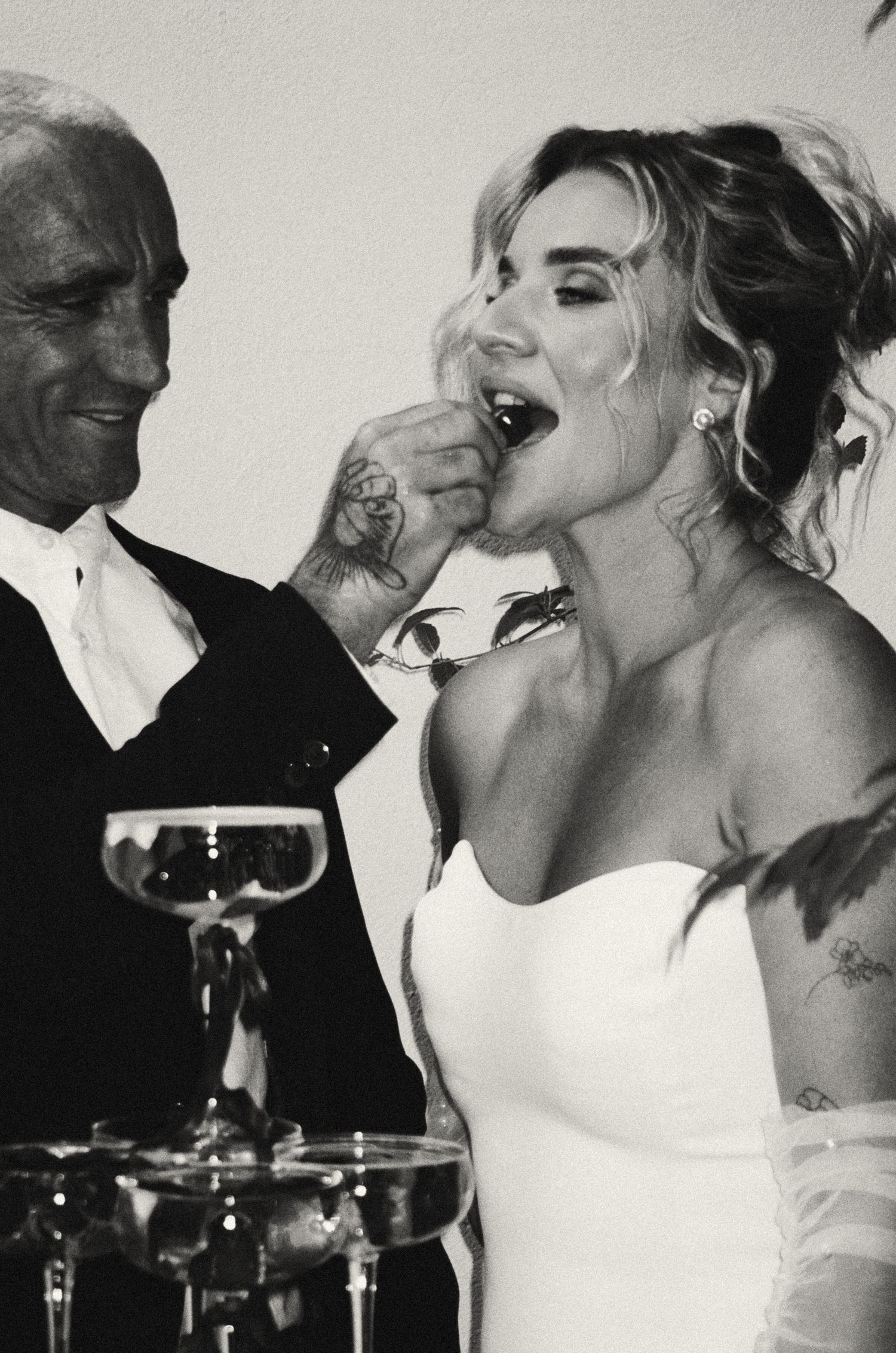 Wedding guests share celebratory drinks and toasts at a reception while wearing formal attire.