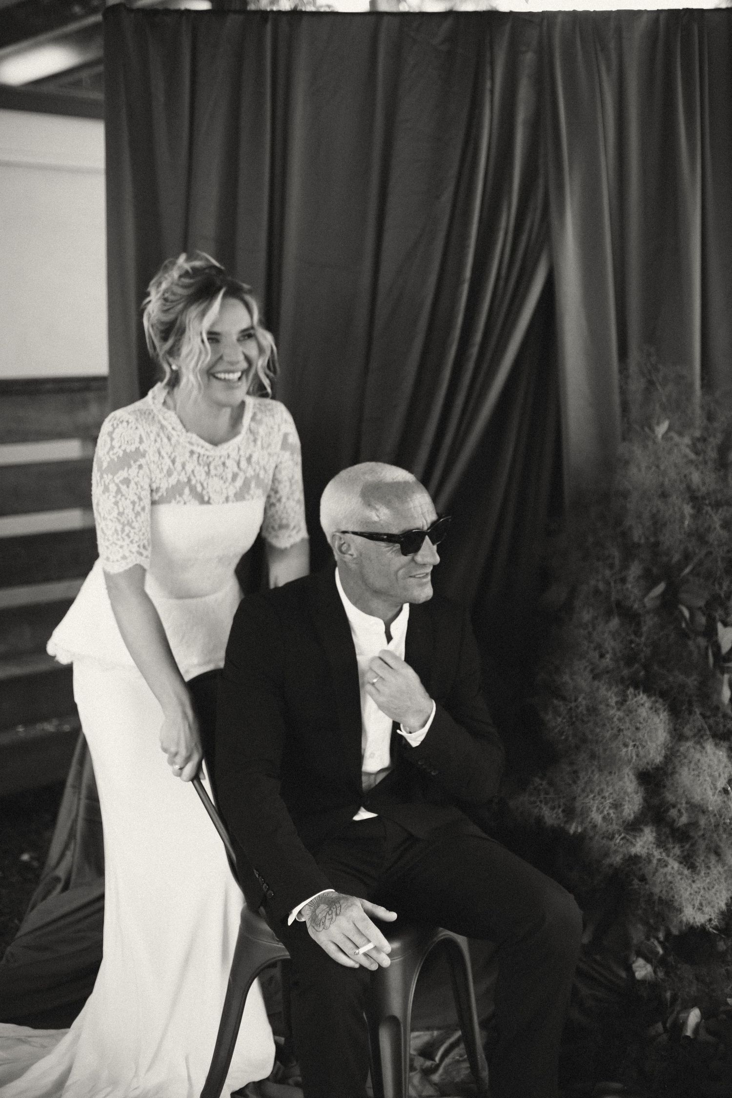 Black and white portraits showing celebratory moments at a formal gathering against a dark curtain backdrop.