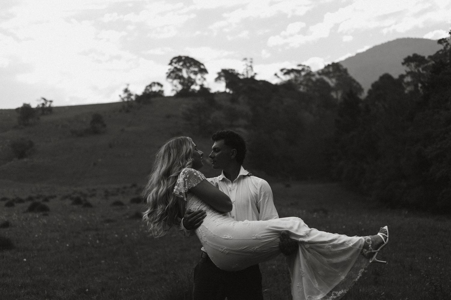 A series of black and white photographs showing intimate moments between a couple in a natural outdoor setting.