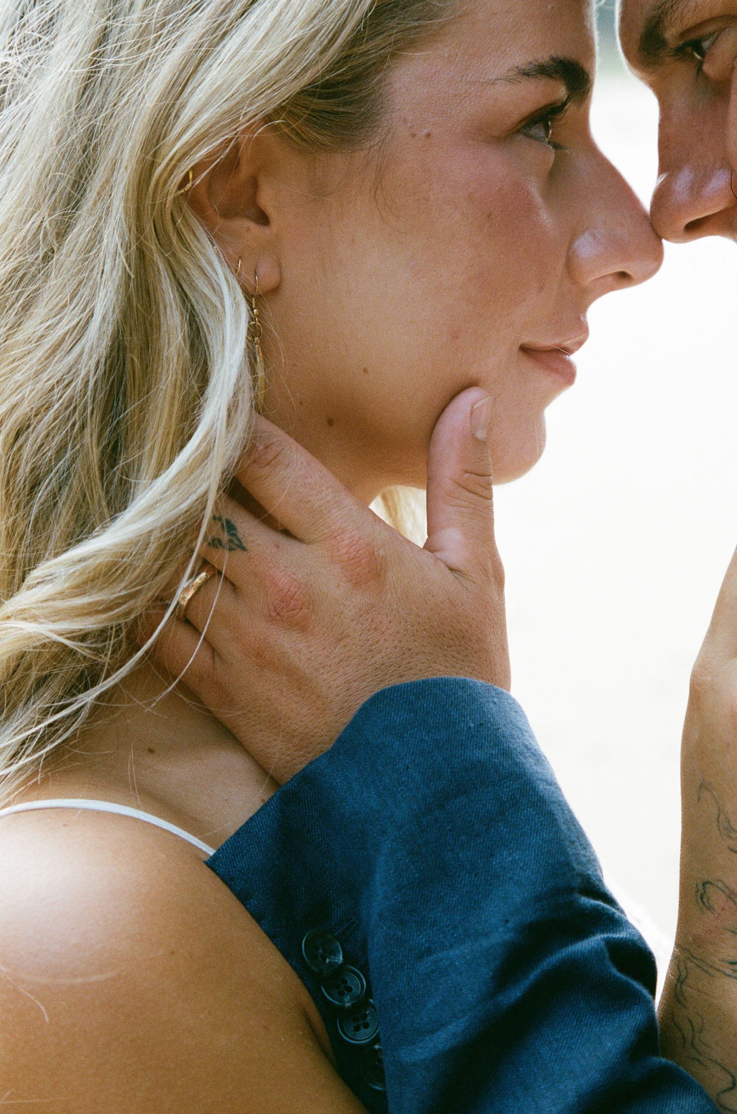 Close-up sequence of a romantic moment between a couple in a navy blue sweater.