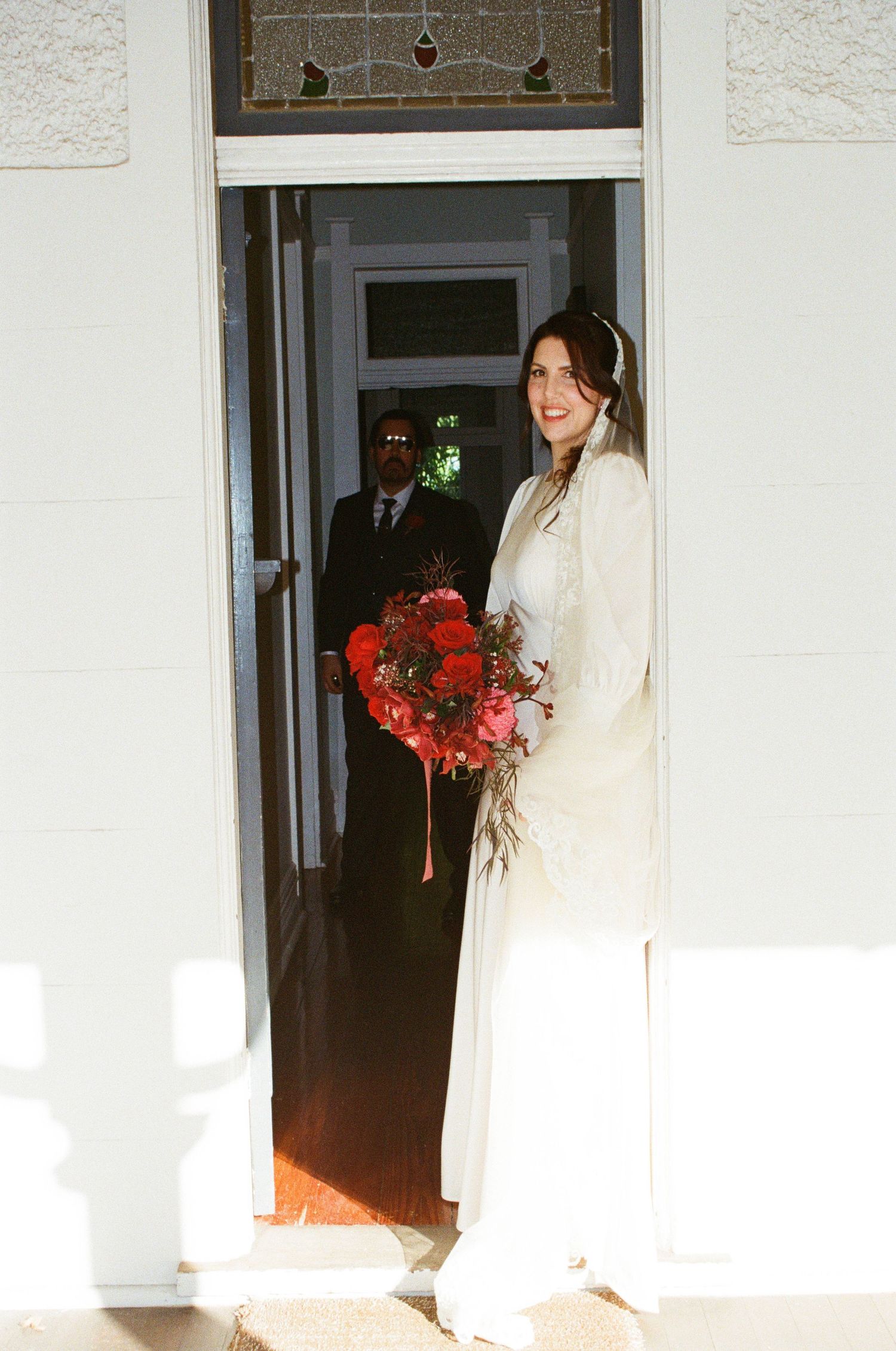 A sequence of shots showing a person in a flowing white dress or gown moving through a dimly lit doorway.