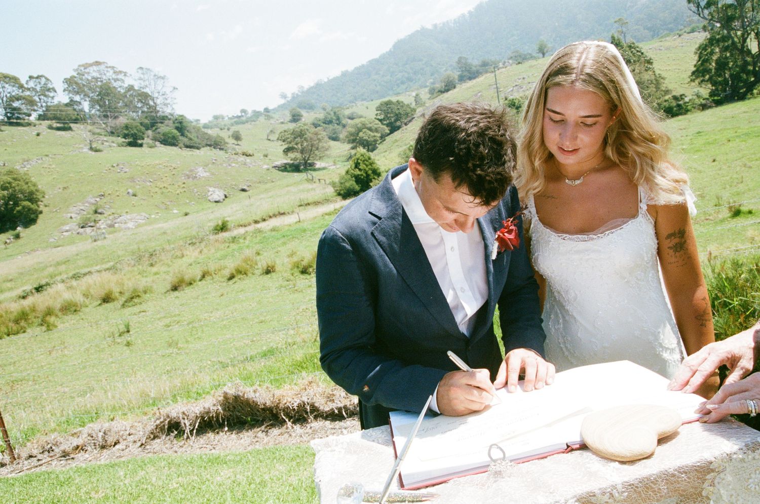 Newlyweds sharing a joyful moment together in a scenic mountain landscape.