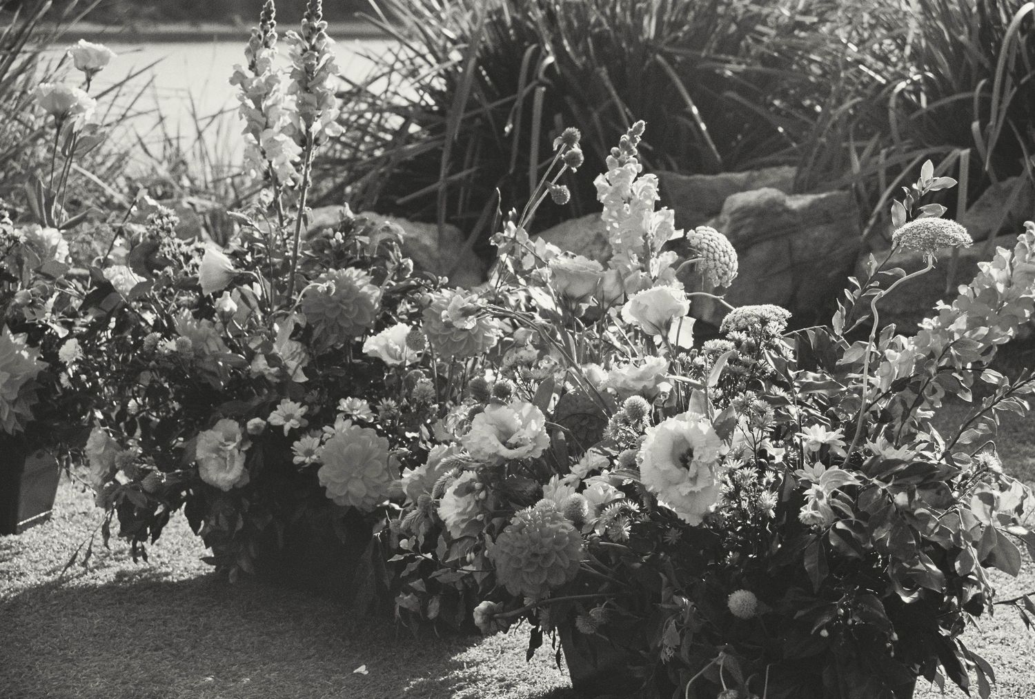 A vintage black and white photograph of a lush floral arrangement featuring roses and delicate blooms.