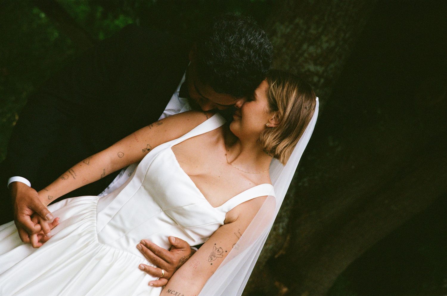 A close-up view showing embracing figures against a dark background with soft lighting.