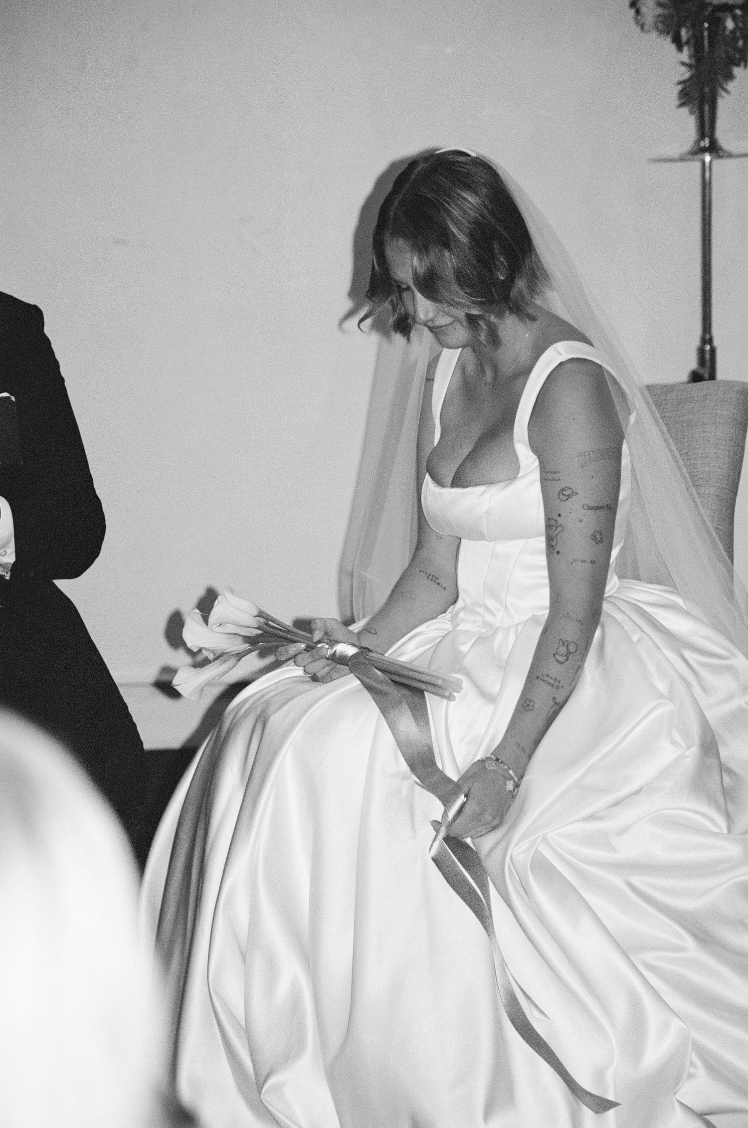 Black and white photograph showing the details of a white wedding dress.