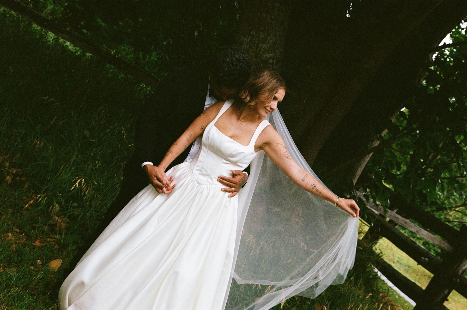 A flowing white wedding dress captured in motion against a natural outdoor backdrop.