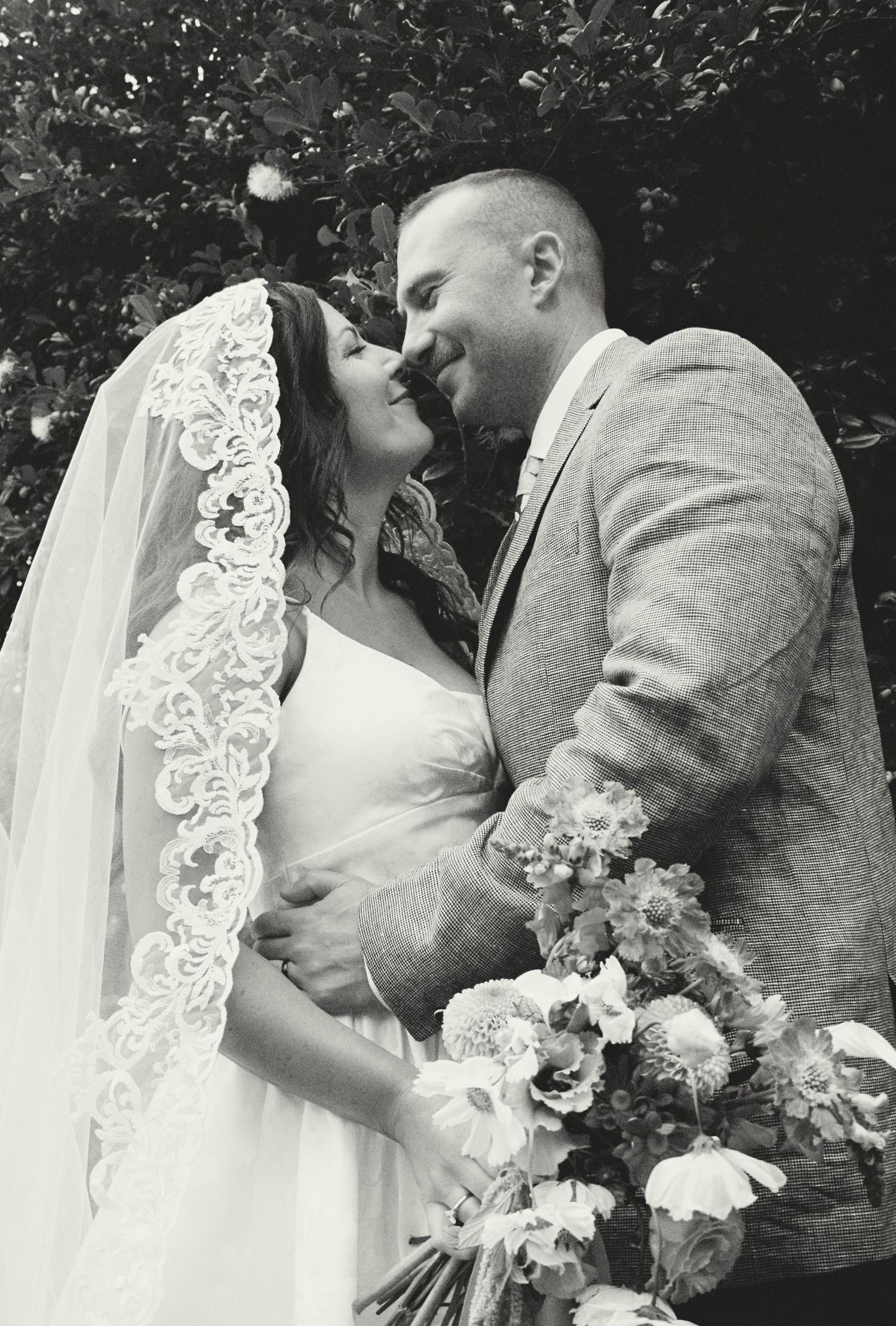 A series of romantic black and white wedding photos showing the newlyweds sharing intimate kisses while the bride holds a bouquet.