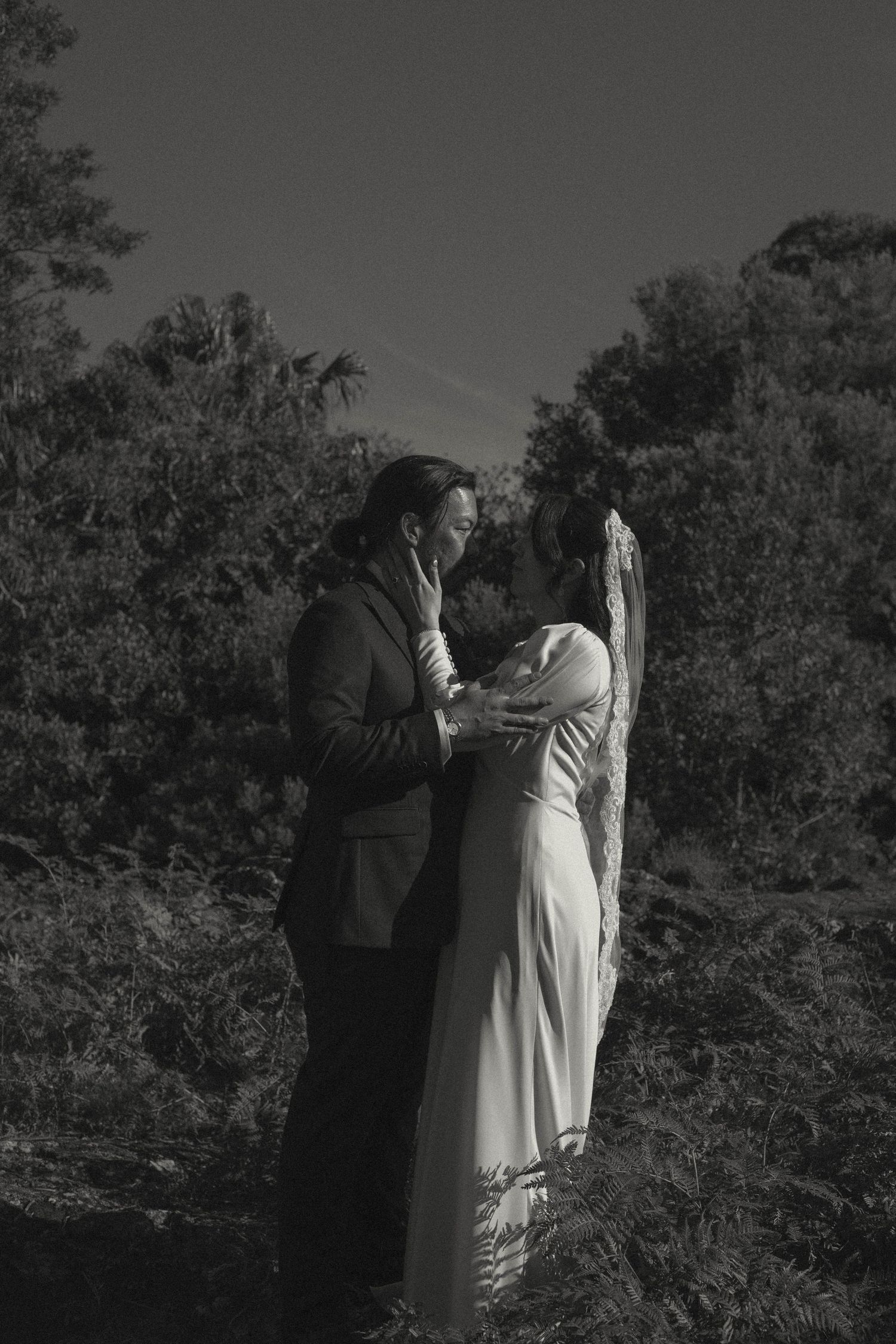 Elegant black and white wedding photography captured in a natural outdoor setting.