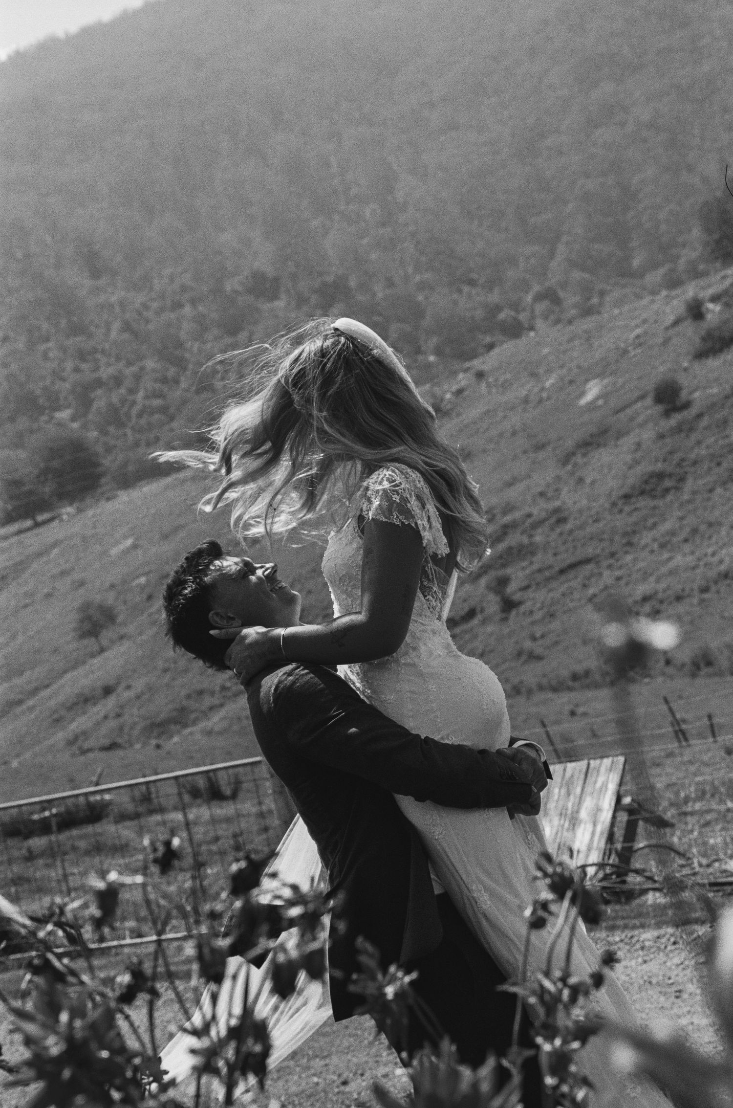 Black and white sequence of a romantic couple embracing and spinning in a mountainous landscape.
