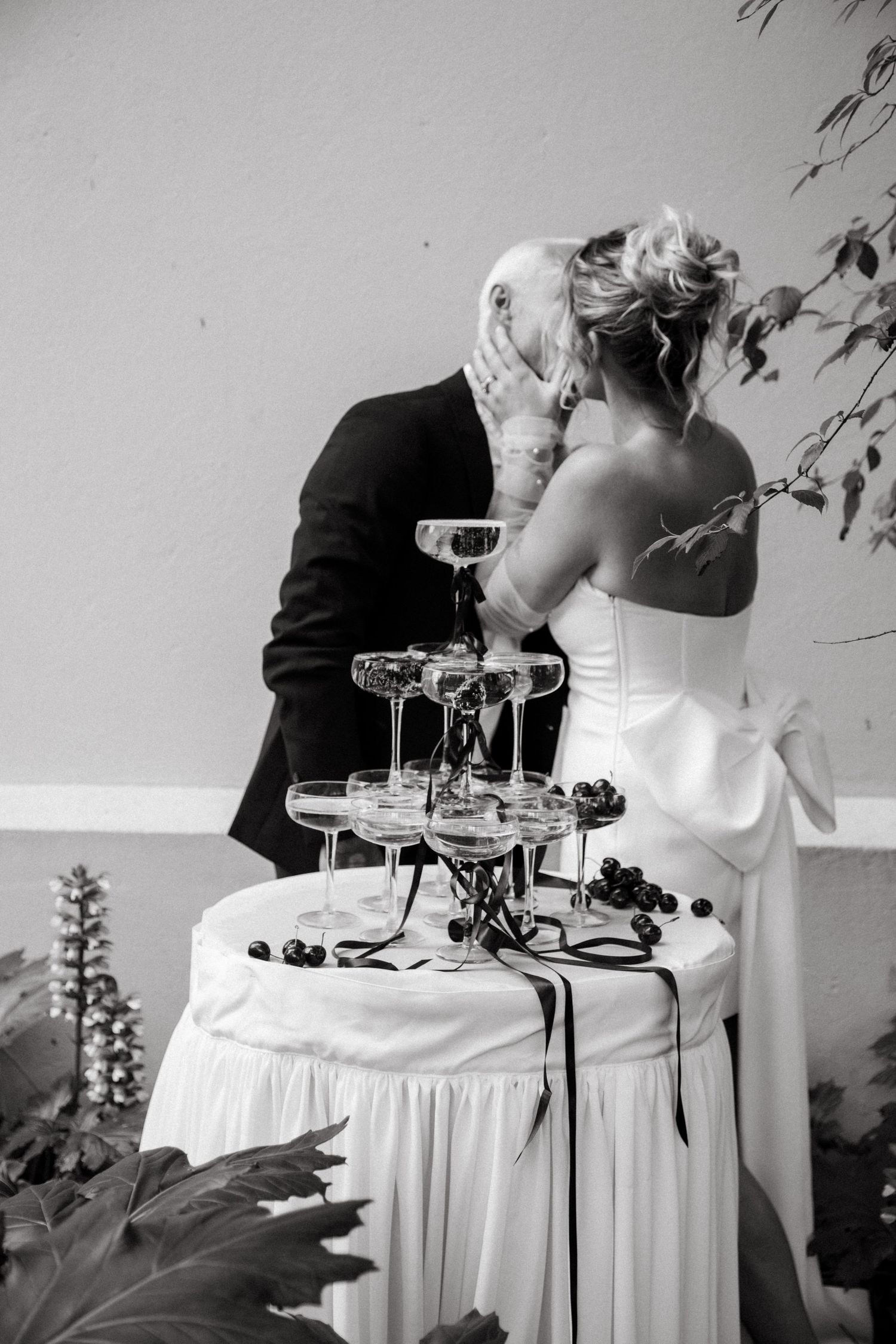 Couple embracing near champagne tower at wedding reception.