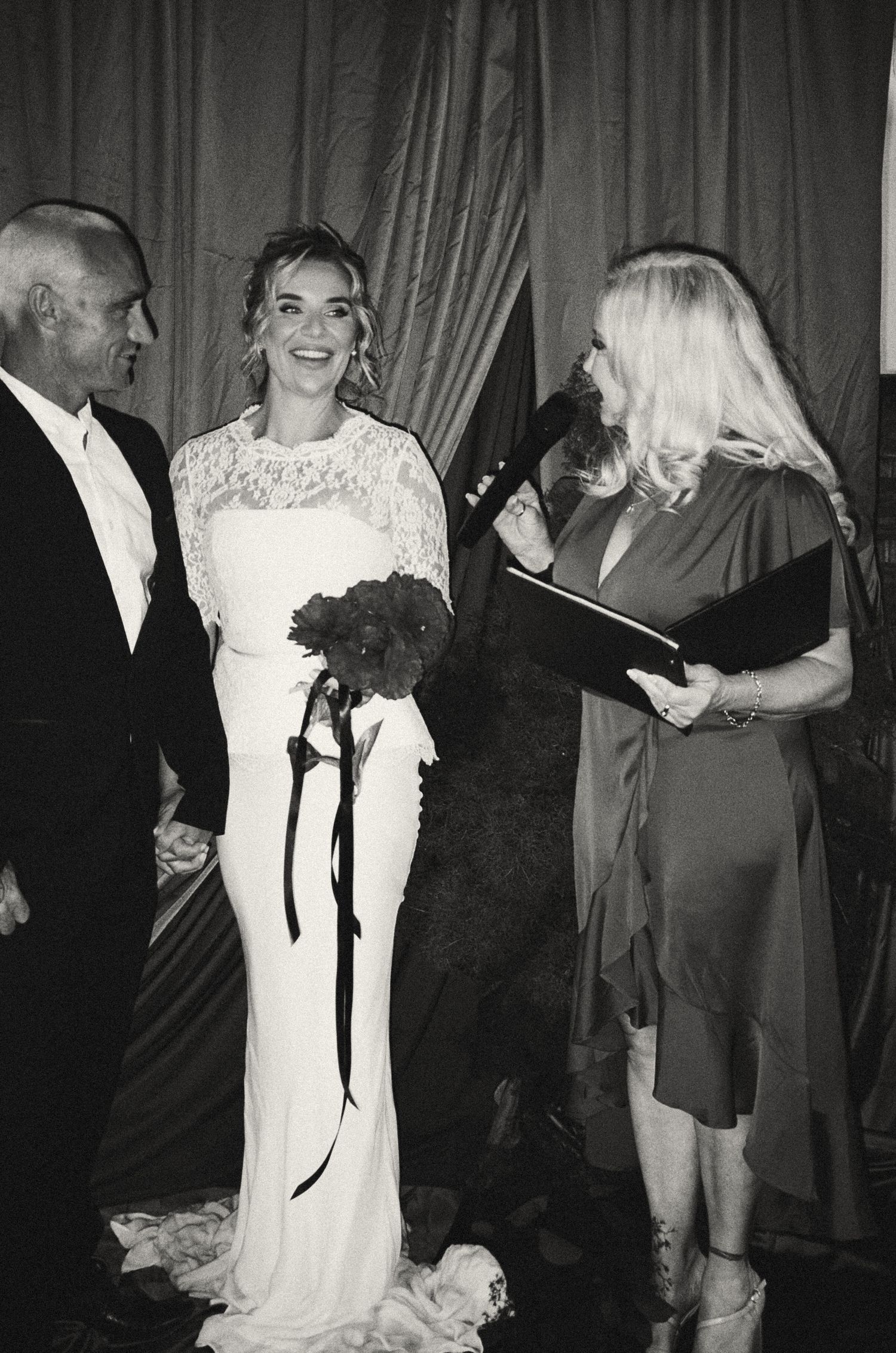 Black and white photo of people dancing and celebrating at a formal event.