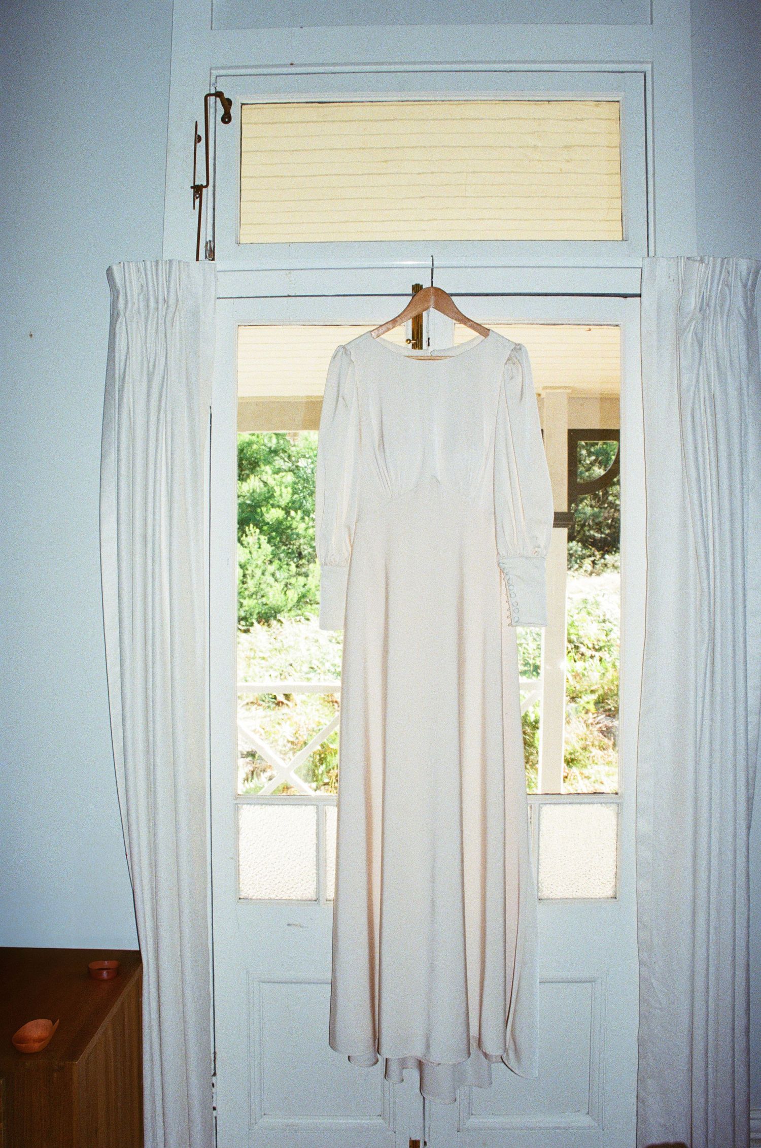 White curtains hanging in front of windows in a room with blue walls.