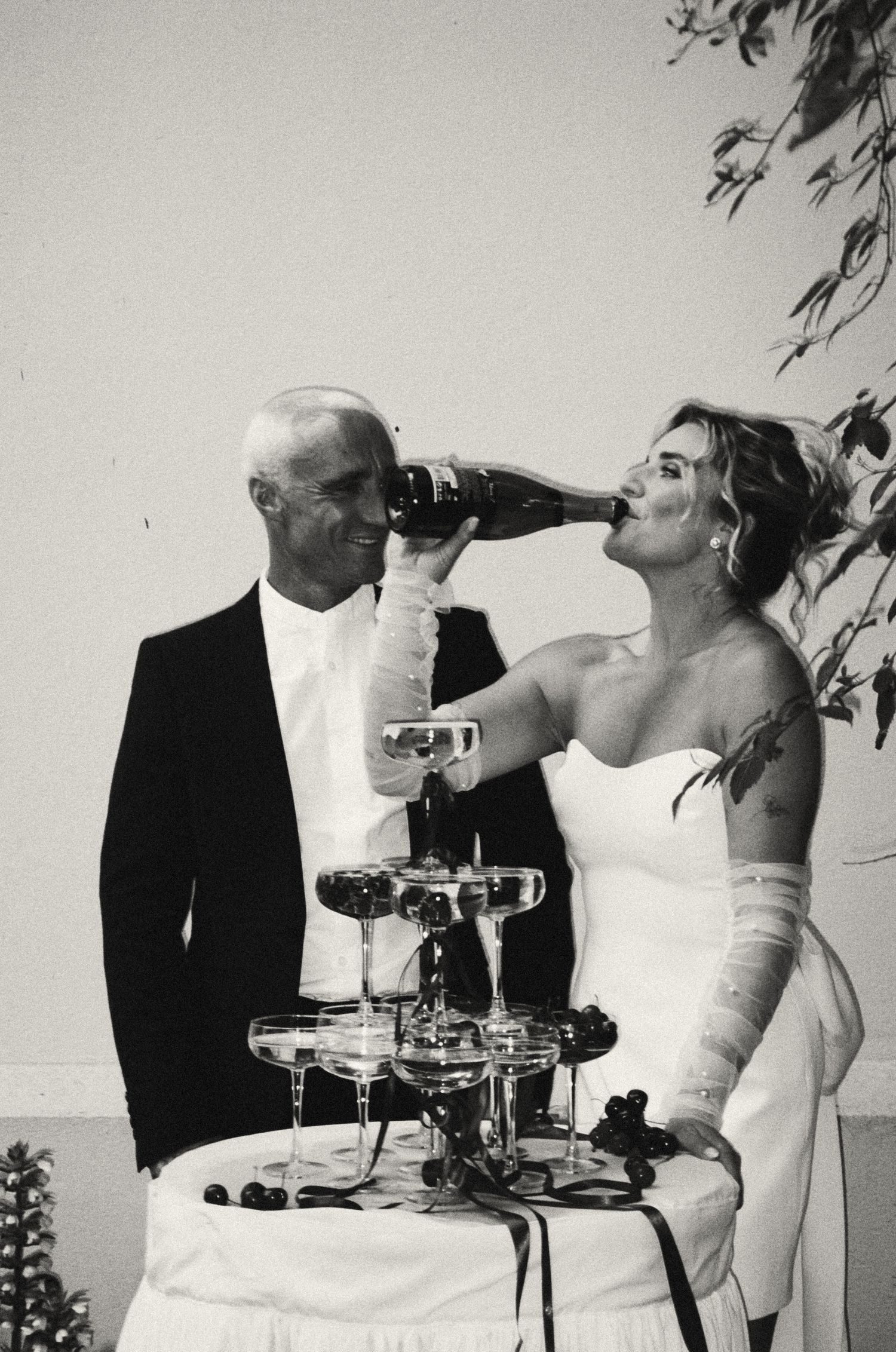 Wedding couple toasting and drinking champagne together in a celebratory moment.