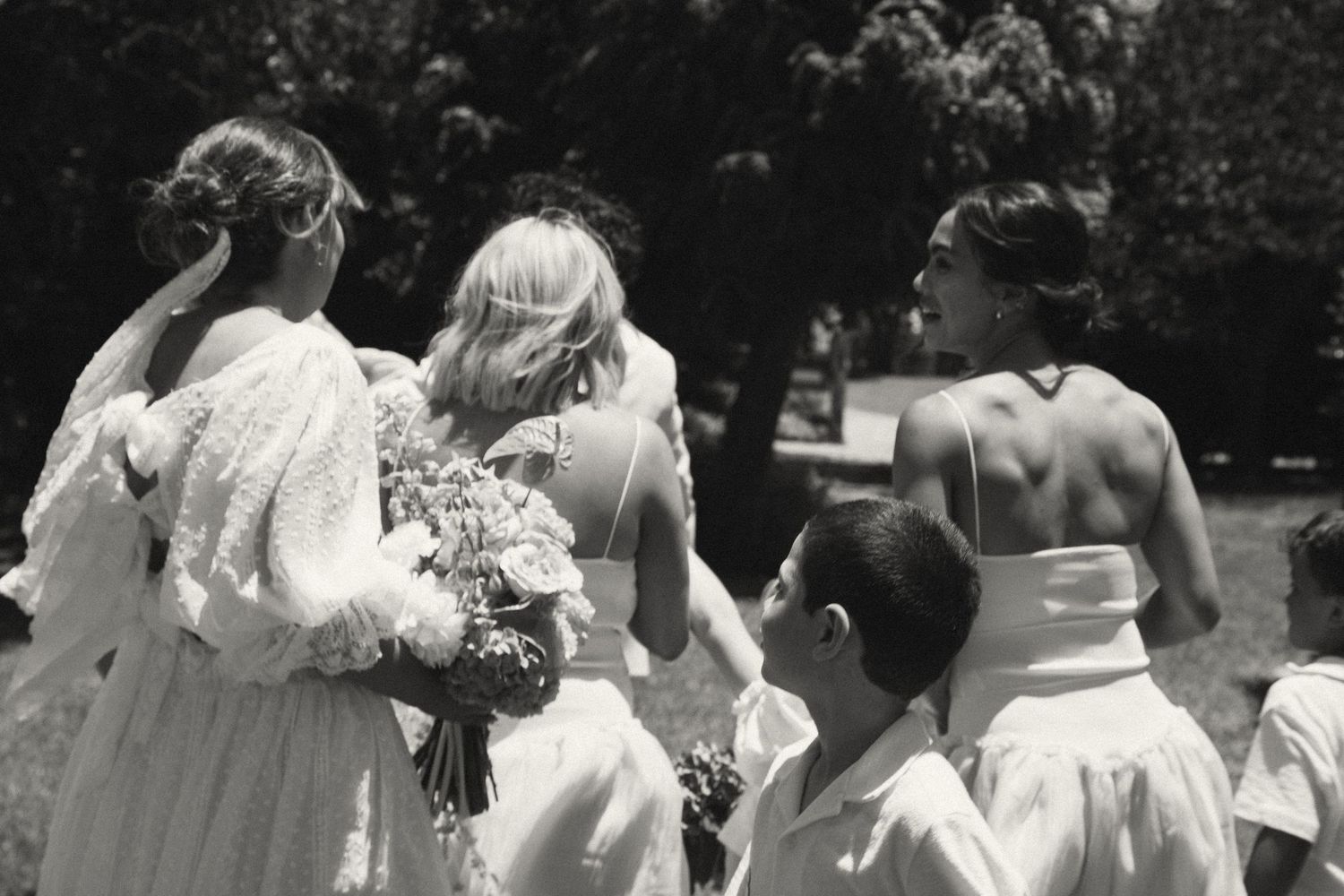 Black and white vintage wedding photograph showing guests gathered outdoors during a ceremony.