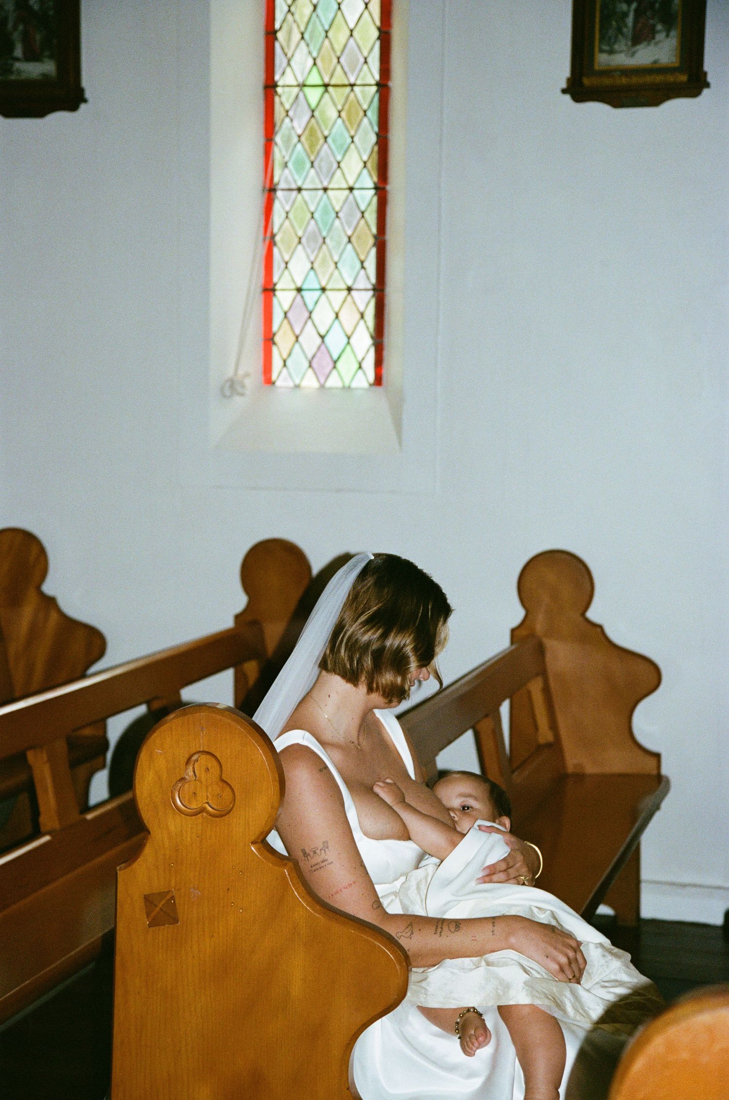 Interior of a church with wooden pews and stained glass windows.